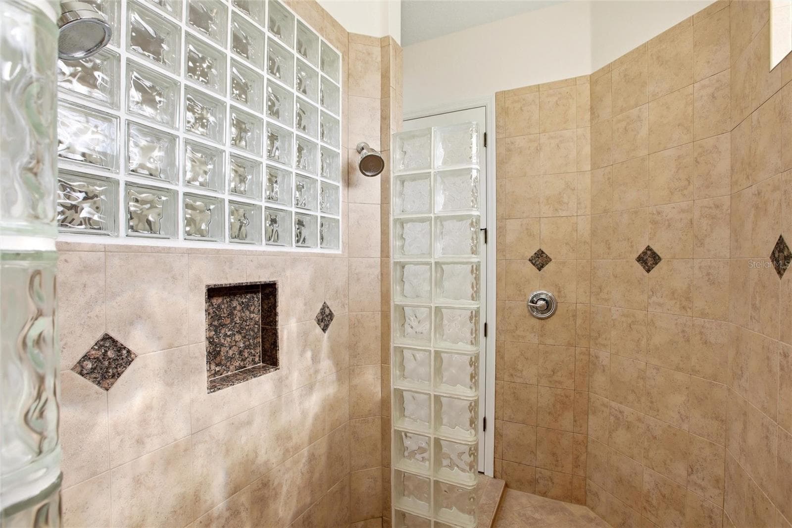 The primary bathroom features a soaking tub, split vanities with dedicated makeup counter space, a spacious walk-in shower with dual shower heads, a private water closet, and dual walk-in closets with custom organization. - 8417 LONE EAGLE WAY, SARASOTA