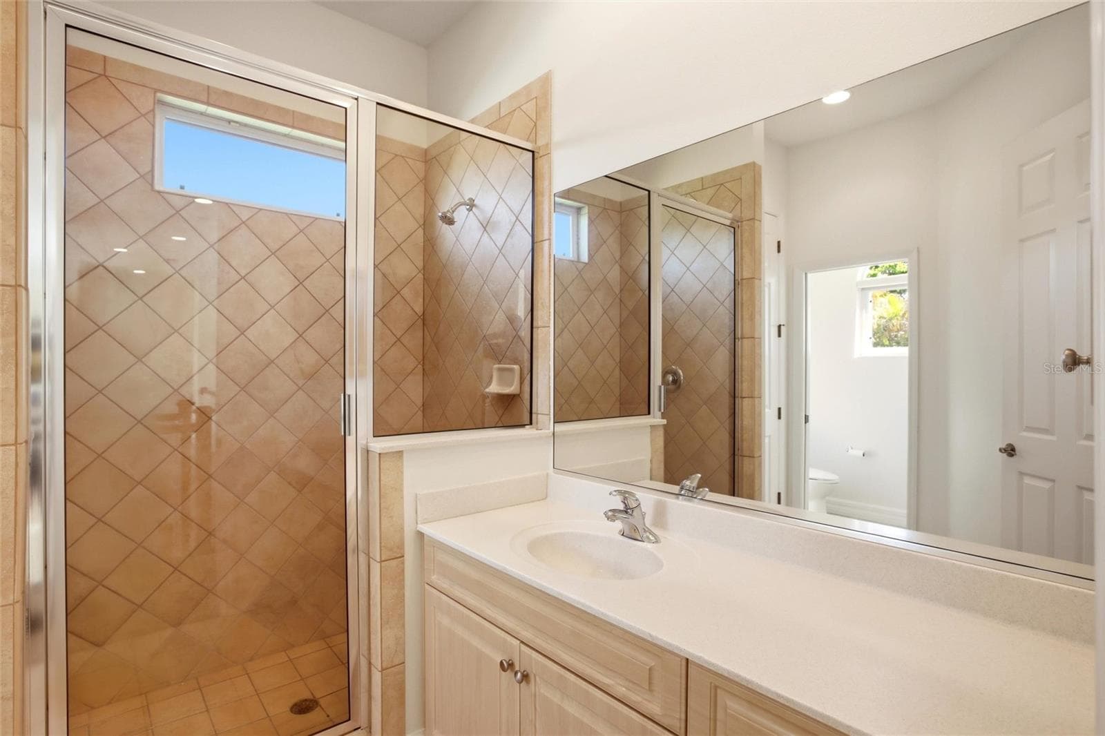 The hall bathroom features a spacious walk-in shower, a sink vanity, a private water closet, and a linen closet, and is conveniently accessible from both the bonus room and the upstairs bedrooms. - 8417 LONE EAGLE WAY, SARASOTA