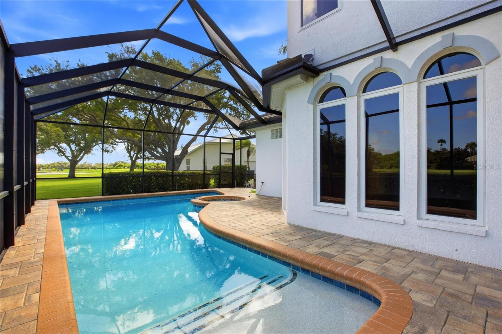 Enjoy resort-style living with a heated pool and spa overlooking the 18th hole, tranquil lake views, and the natural beauty of Misty Creek, where deer are often seen roaming the landscape. - 8417 LONE EAGLE WAY, SARASOTA