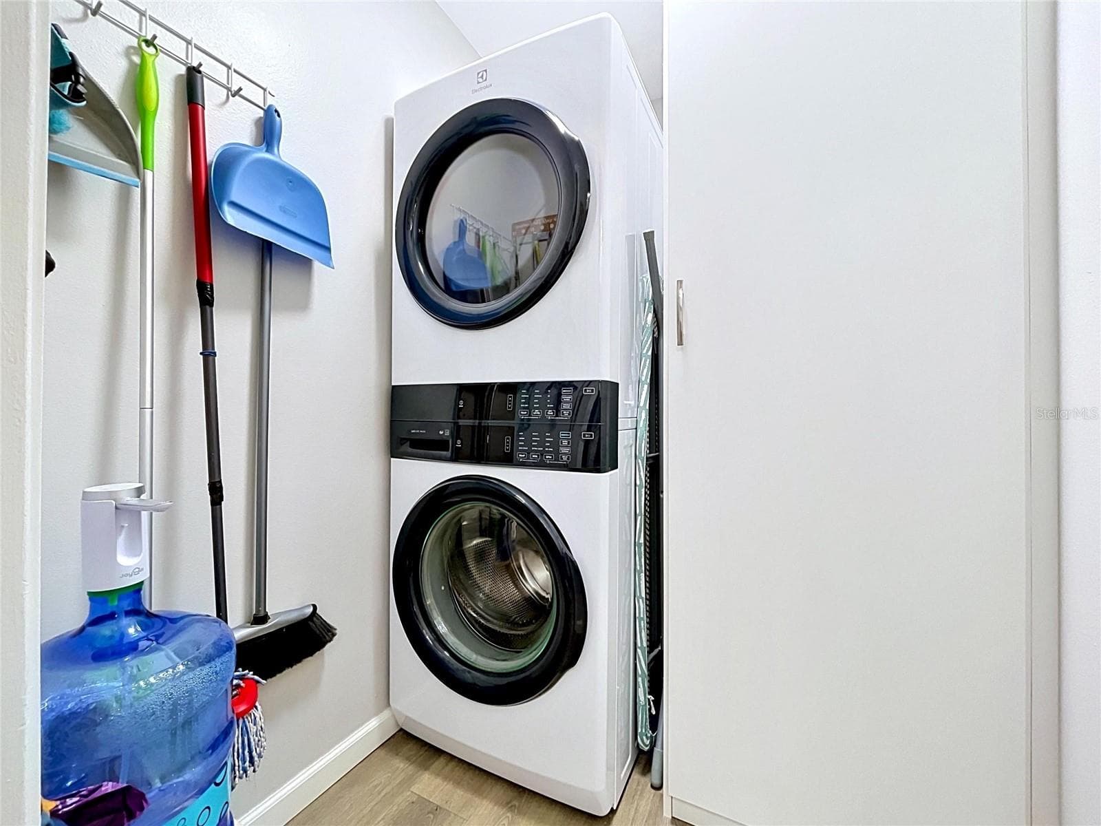 In unit laundry closet with custom built cabinets for optimal storage and pantry space. - 1006 LENNOX RD W #1006, PALM HARBOR