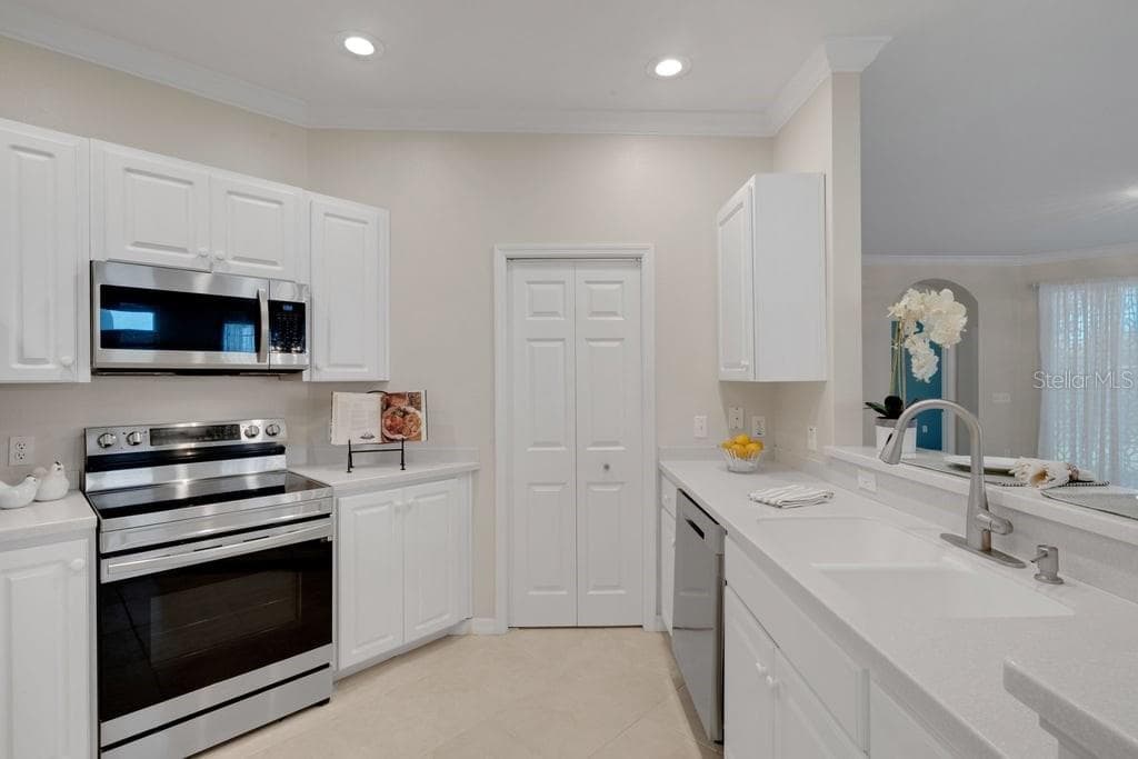 The kitchen is light and bright with a full-size walk-in pantry. - 684 GRASSLANDS VILLAGE CIR, LAKELAND
