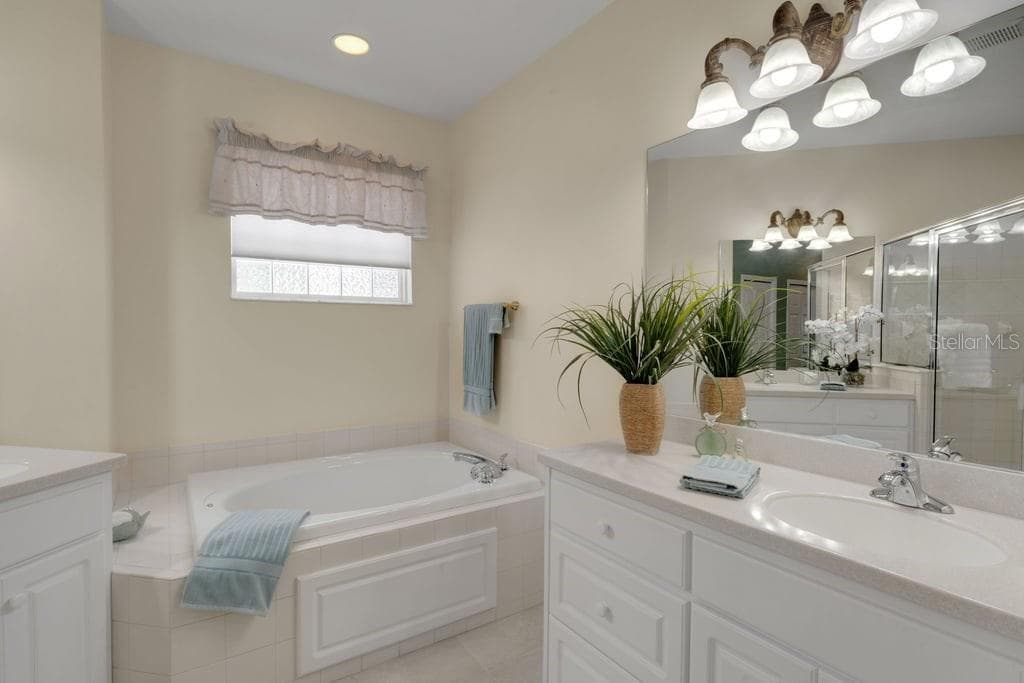 The ensuite bathroom features a deep soaking tub, dual vanities and . . . - 684 GRASSLANDS VILLAGE CIR, LAKELAND