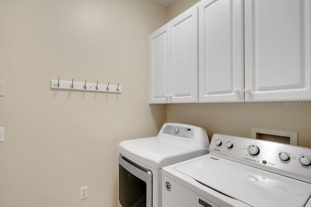 The inside utility room comes complete with washer and dryer and great cabinet storage. - 684 GRASSLANDS VILLAGE CIR, LAKELAND