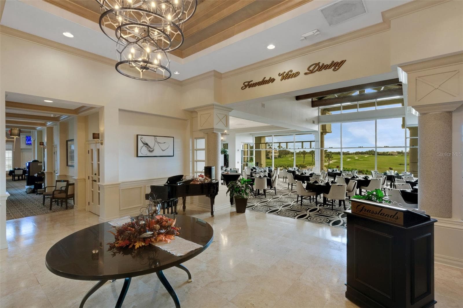 The main dining room affords panoramic views of the golf course beyond its floor to ceiling windows. - 684 GRASSLANDS VILLAGE CIR, LAKELAND