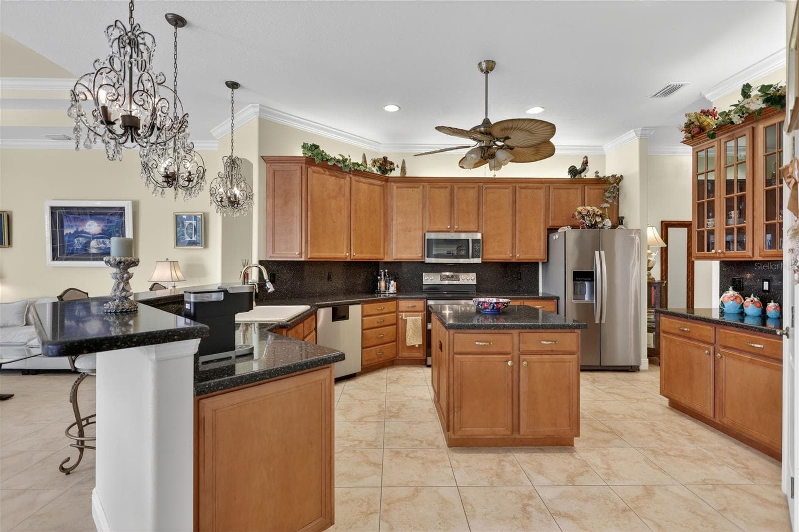 The oversized kitchen is designed for both everyday living and entertaining, featuring extensive cabinetry, generous prep space, a center island, and abundant storage. - 1210 408TH CT E, MYAKKA CITY