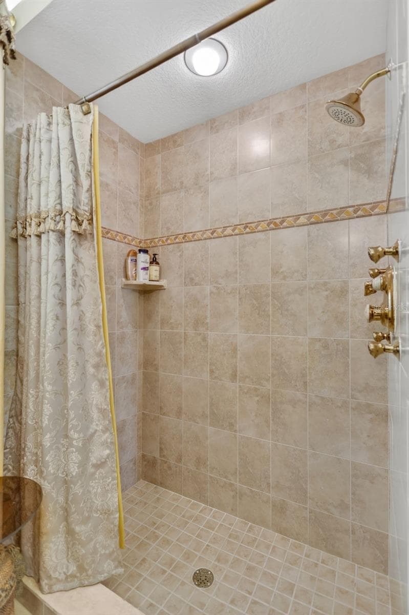 The guest bath showcases timeless tile finishes, a walk-in shower, and convenient access to the adjacent guest accommodations. - 1210 408TH CT E, MYAKKA CITY
