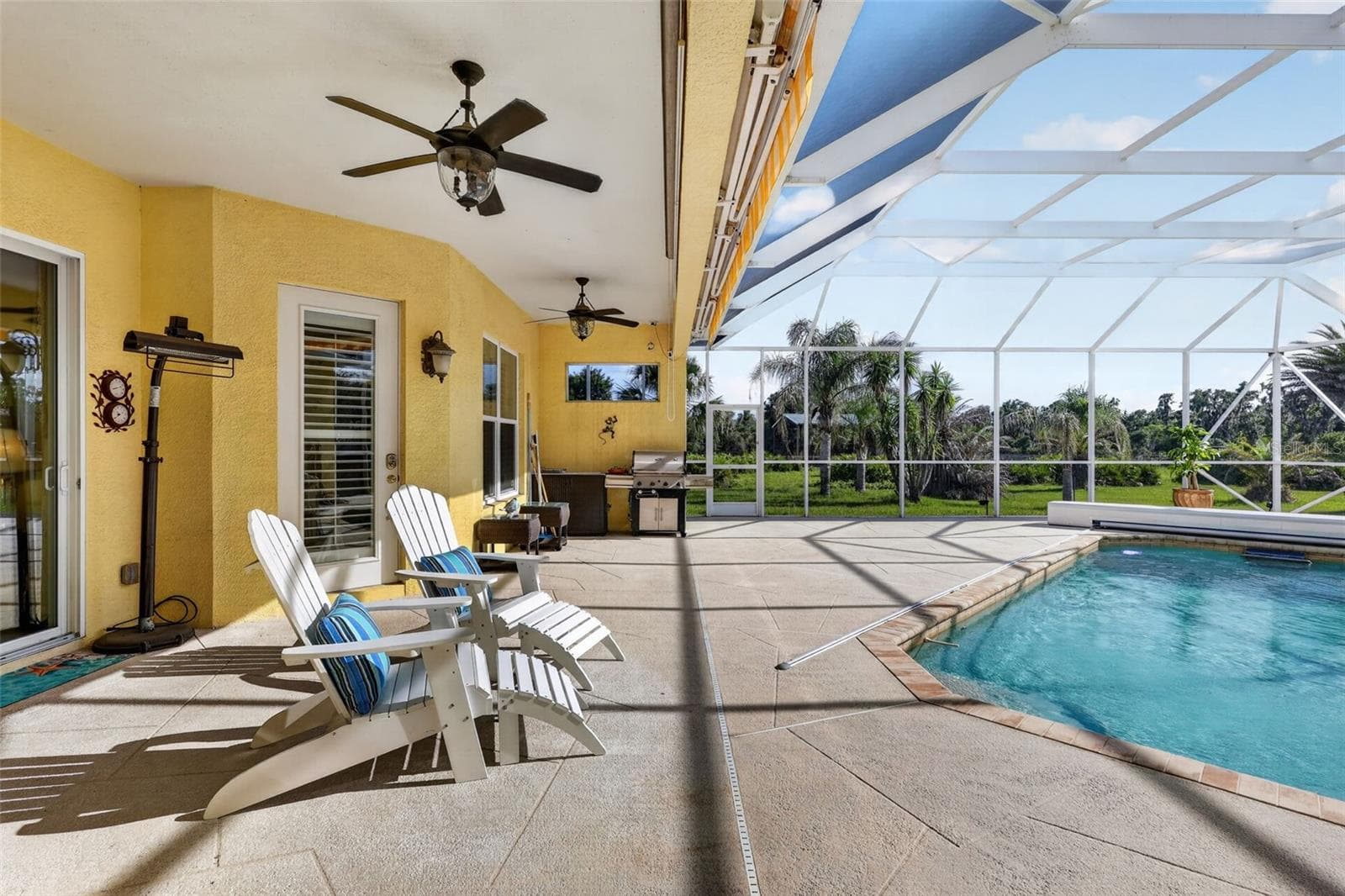 Enjoy year-round outdoor living with multiple gathering spaces overlooking the heated saltwater pool and beautifully landscaped acreage. - 1210 408TH CT E, MYAKKA CITY