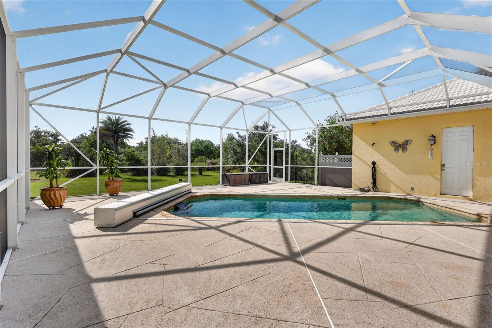 The expansive screened pool enclosure offers exceptional privacy, abundant deck space, and peaceful preserve views, creating a true resort-style outdoor retreat. - 1210 408TH CT E, MYAKKA CITY