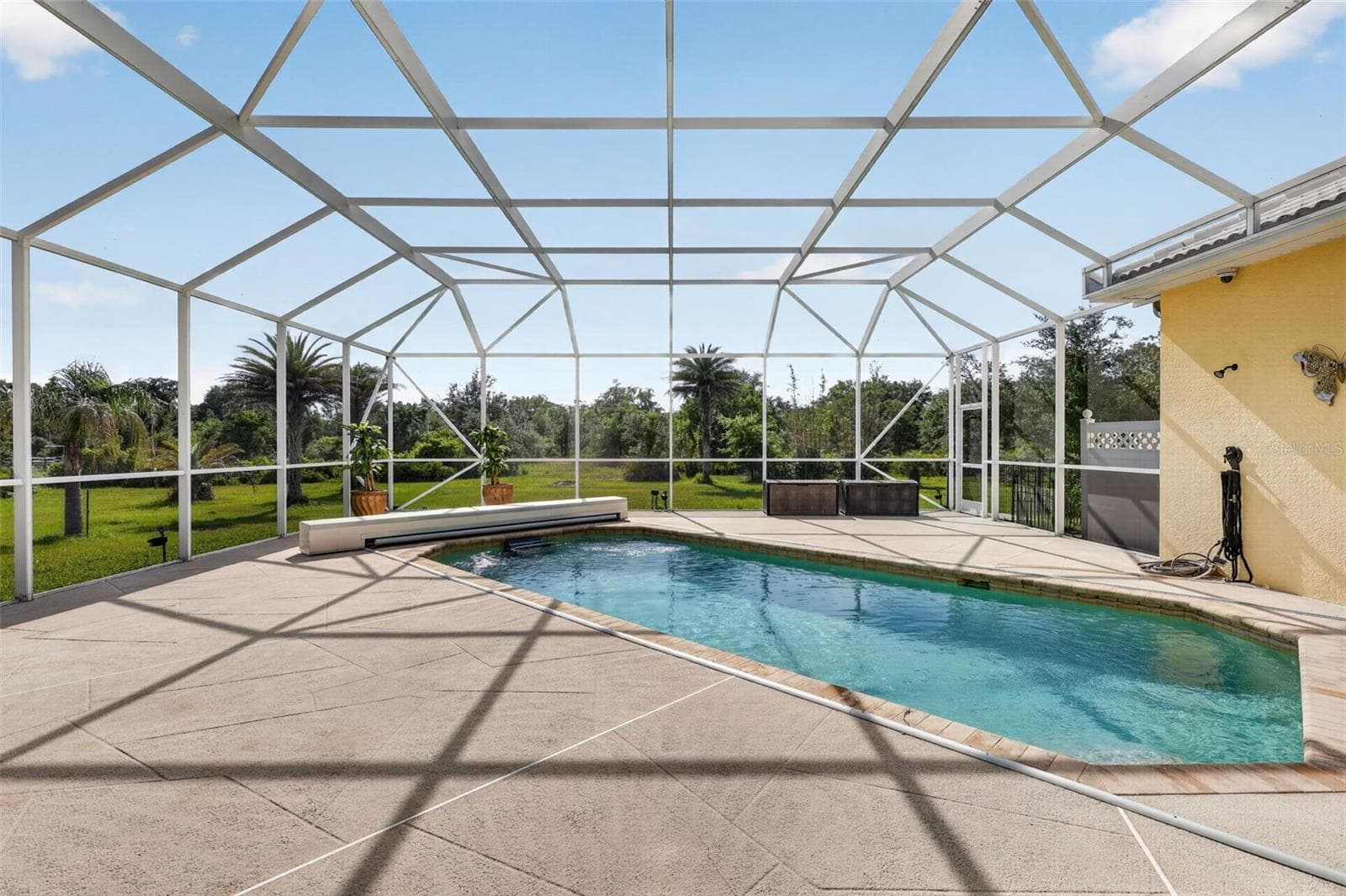 Surrounded by mature landscaping and open green space, the heated saltwater pool and oversized lanai provide the perfect setting for relaxation and entertaining. - 1210 408TH CT E, MYAKKA CITY