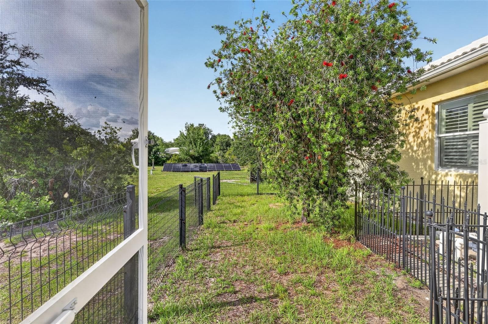 An adjacent fenced dog run provides a secure and convenient outdoor area for pets, thoughtfully separated from the pool enclosure while remaining easily accessible. - 1210 408TH CT E, MYAKKA CITY