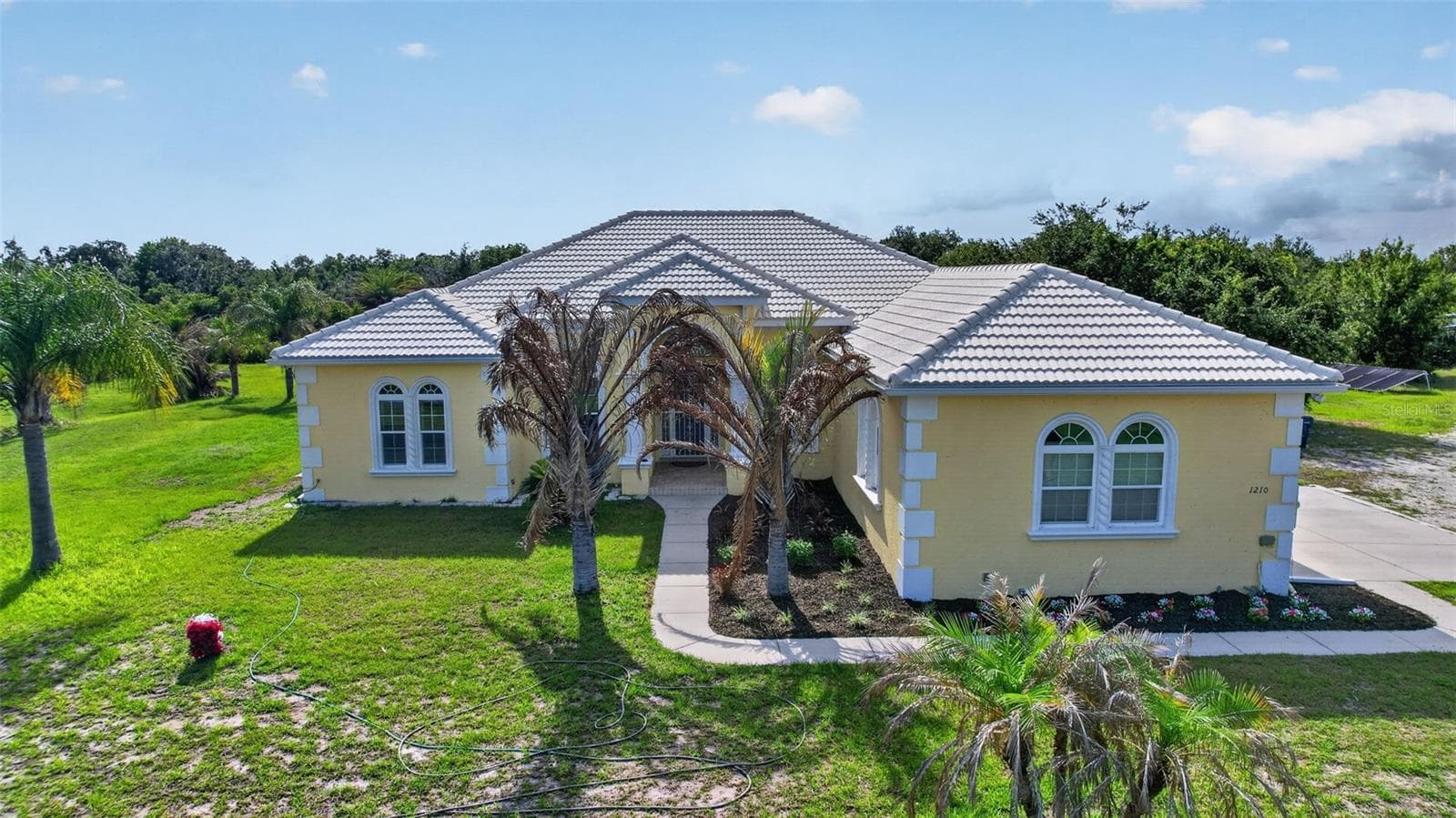 Impressive custom residence showcasing barrel tile roofing, expansive grounds, and a thoughtfully designed floor plan with superior living space. - 1210 408TH CT E, MYAKKA CITY
