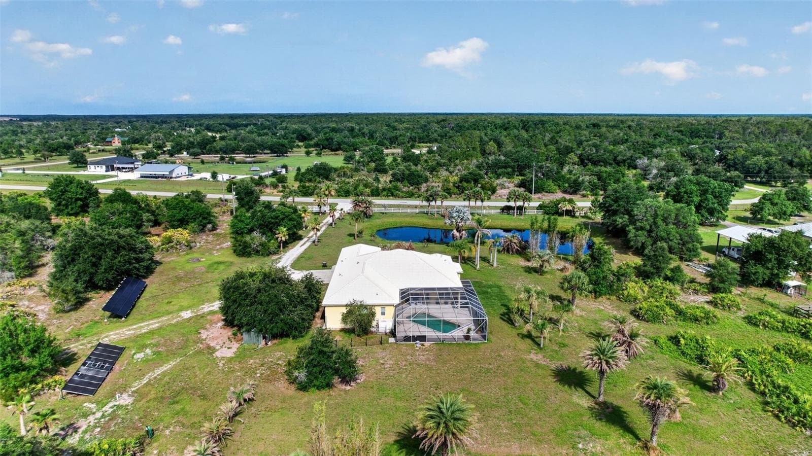 From above, the property's impressive scale becomes apparent, offering a rare combination of privacy, open space, mature landscaping, and a tranquil country setting. - 1210 408TH CT E, MYAKKA CITY