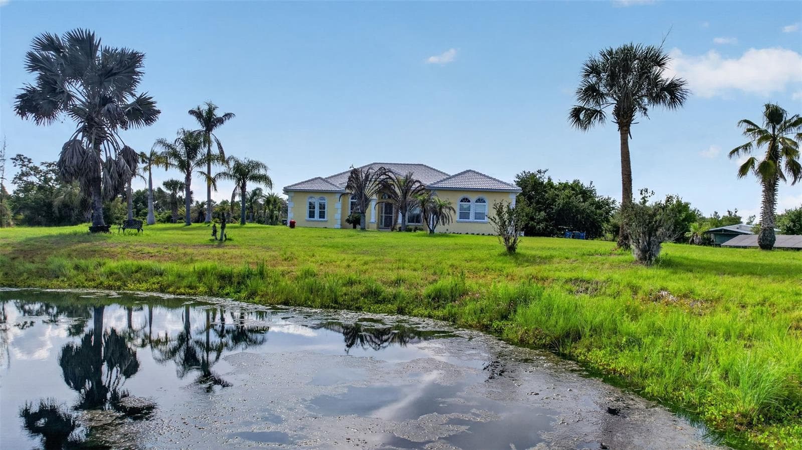 The private pond enhances the property's natural beauty, creating a serene backdrop and attracting local wildlife. - 1210 408TH CT E, MYAKKA CITY