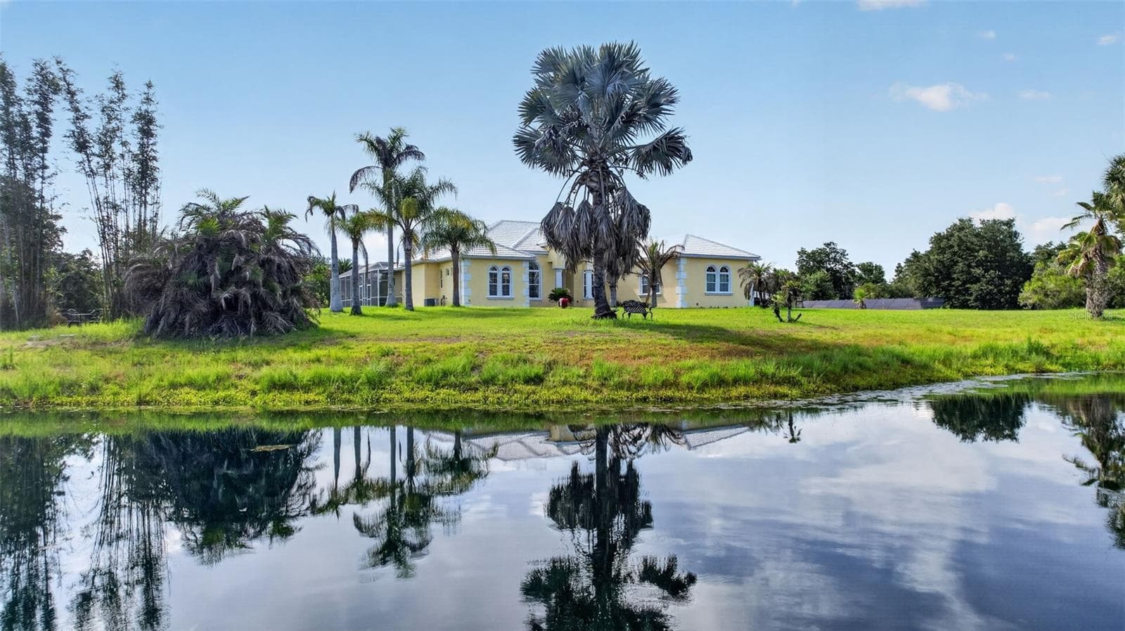 Enjoy the tranquility of country living with a private pond, open green space, and a beautifully positioned estate designed to maximize privacy and outdoor enjoyment. - 1210 408TH CT E, MYAKKA CITY