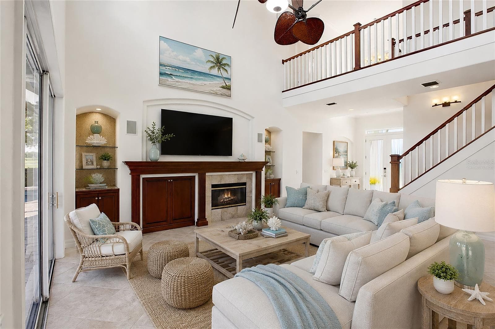 This photo is virtually staged. The family room features soaring cathedral ceilings, a fireplace with mantel, and sliding glass doors opening to the lanai, while flowing seamlessly into the kitchen for comfortable everyday living and entertaining. - 8417 LONE EAGLE WAY, SARASOTA