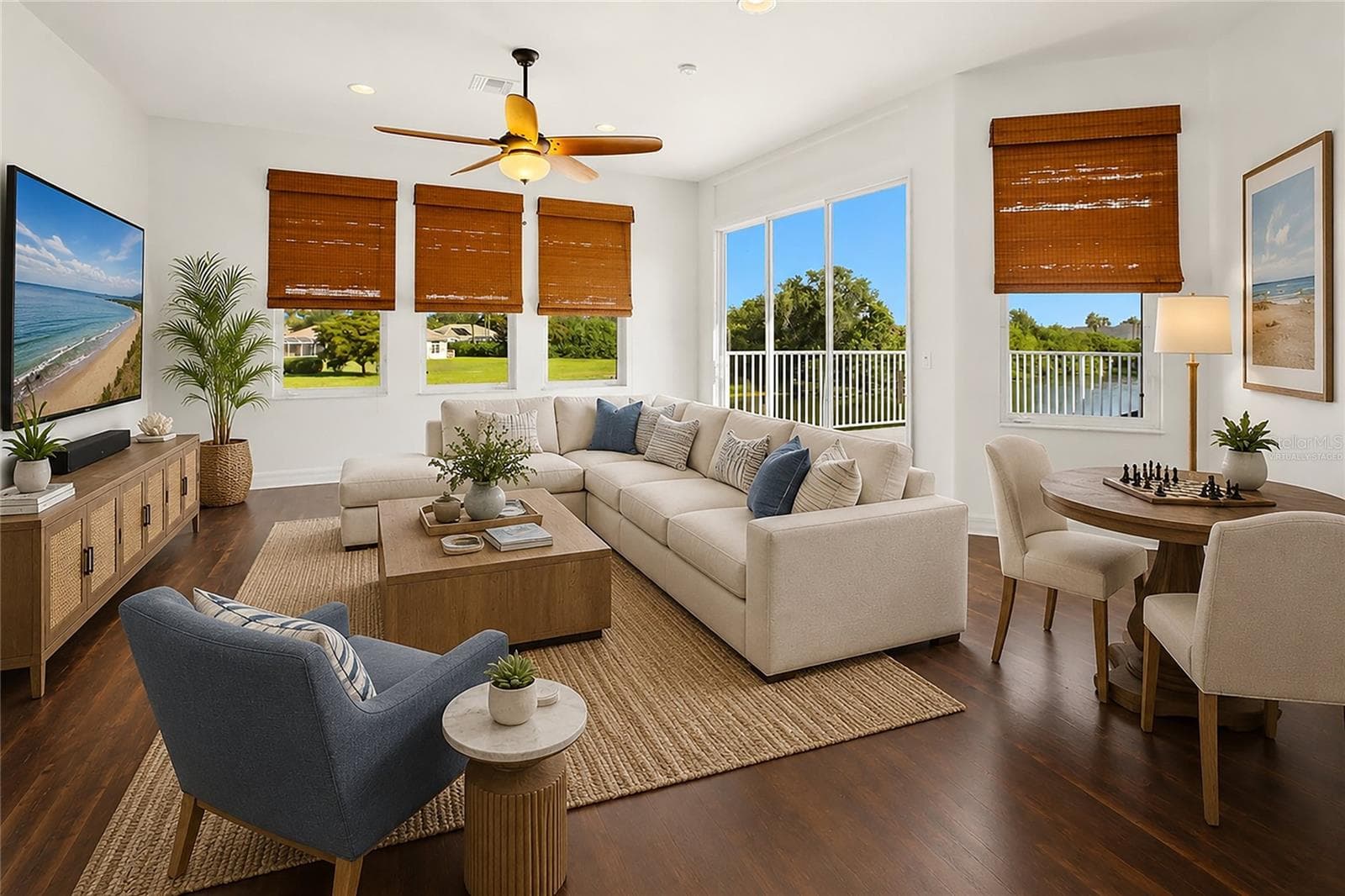 This photo is virtually staged. The spacious bonus room offers exceptional versatility, serving as an ideal playroom, guest quarters, media room, or workout space. It is well-appointed with a wet bar, refrigerator, washer and dryer, and a large storage closet, and opens through sliding glass doors to a private second-floor balcony overlooking the lake and golf course. A dumbwaiter provides convenient access from the kitchen below. - 8417 LONE EAGLE WAY, SARASOTA