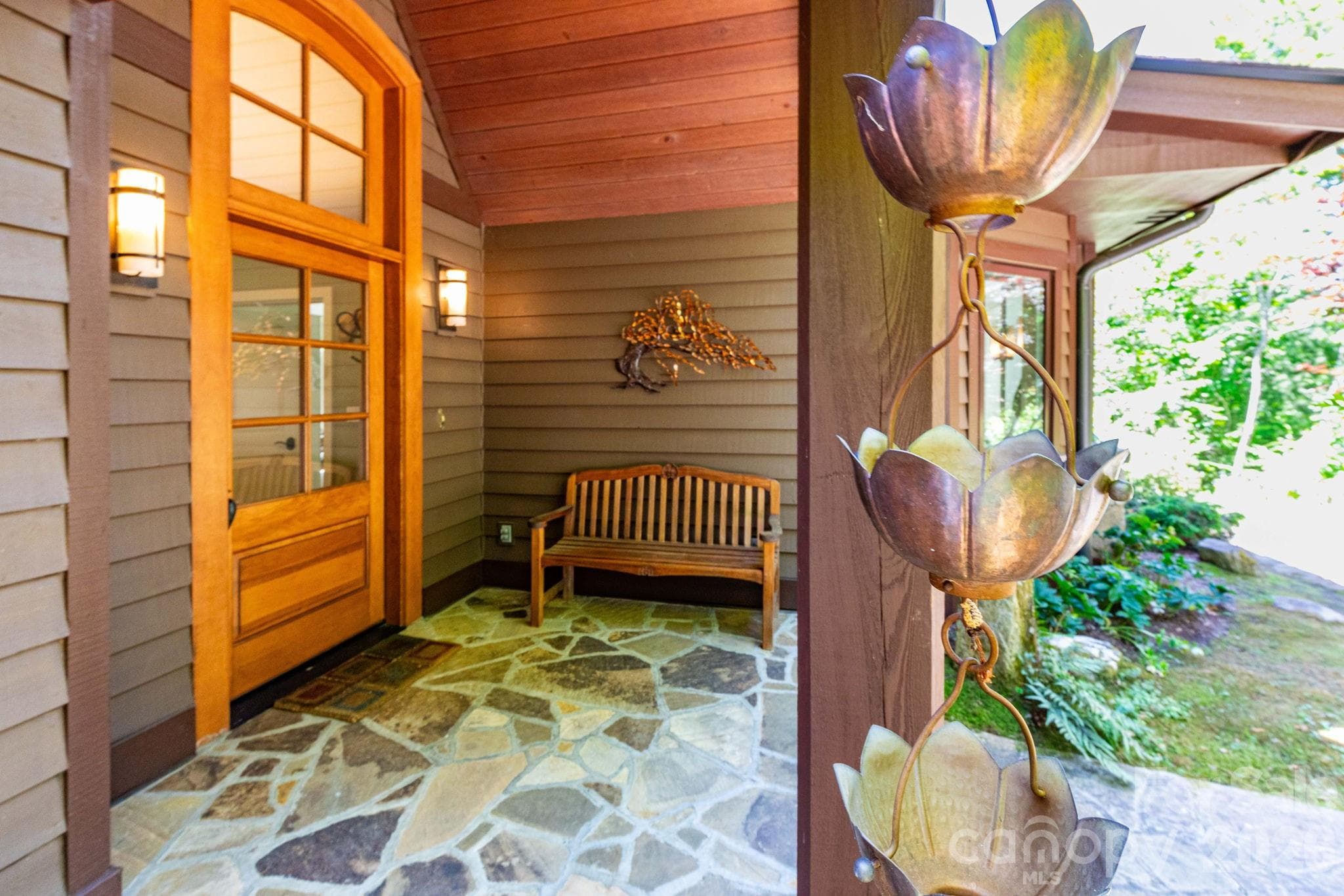 Welcoming covered entry to the main residence featuring beautiful wood craftsmanship, stone flooring, and warm architectural details. - 29 Gardner Drive, Asheville