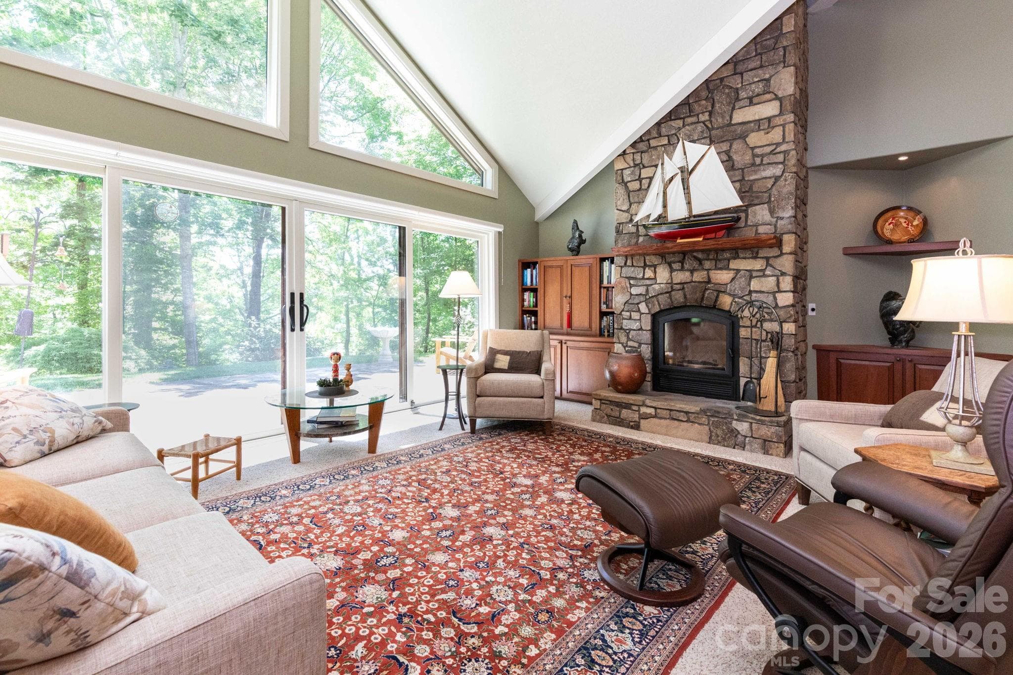 Stunning stone fireplace anchors the spacious living area, while expansive windows frame tranquil wooded views and fill the home with natural light. - 29 Gardner Drive, Asheville