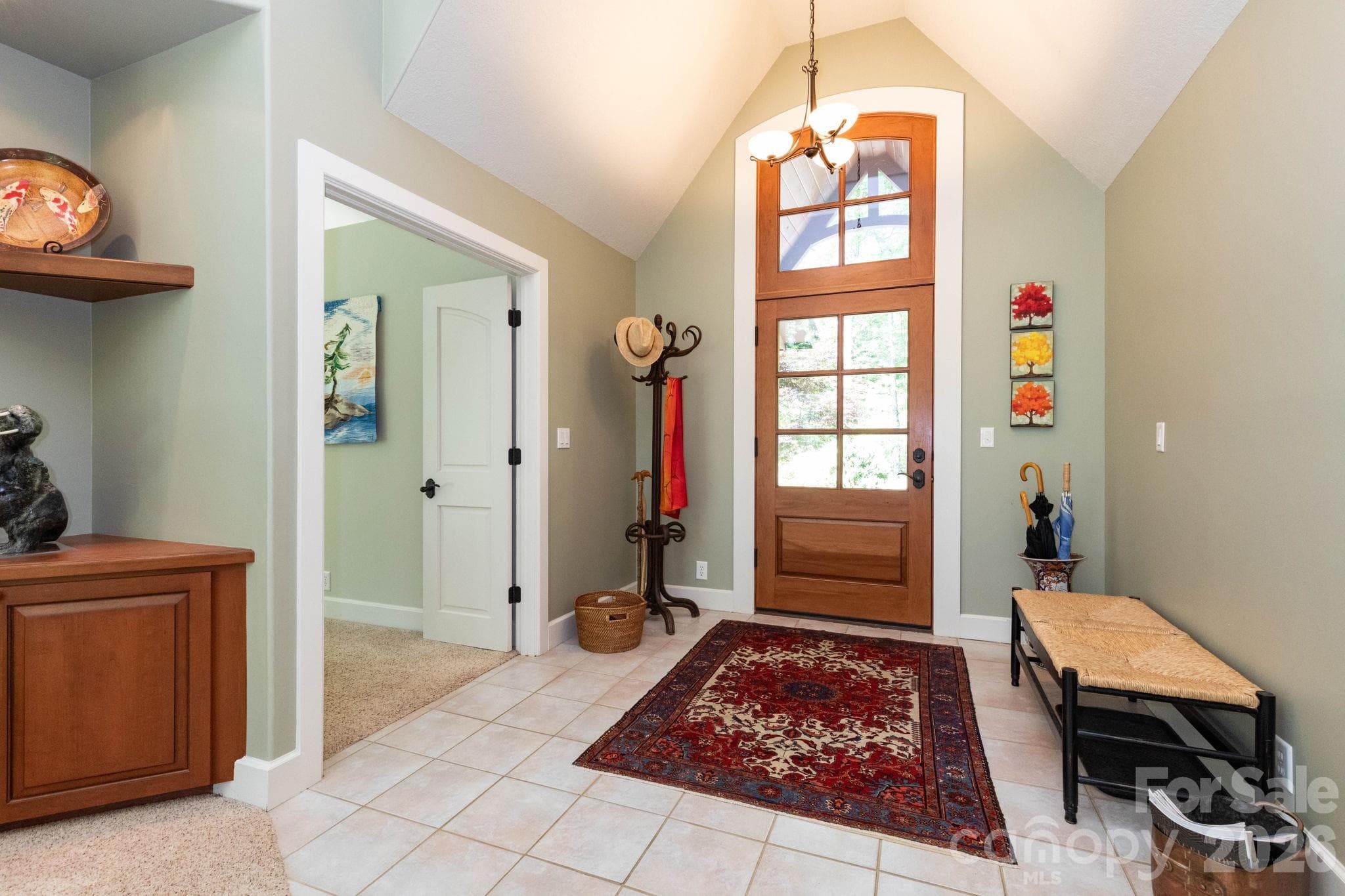 Welcoming entry foyer with soaring ceilings, custom wood front door, and abundant natural light creates an elegant first impression the moment you step inside. - 29 Gardner Drive, Asheville