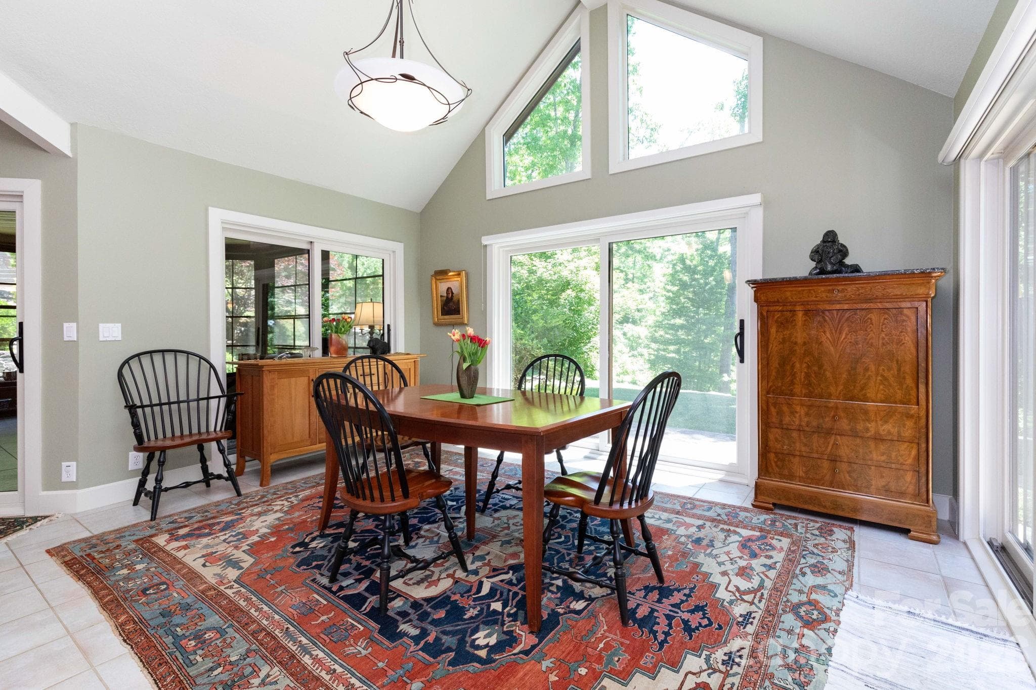 Bright and inviting dining space surrounded by oversized windows and peaceful views of the surrounding landscape, offering the perfect backdrop for everyday meals or special gatherings. - 29 Gardner Drive, Asheville