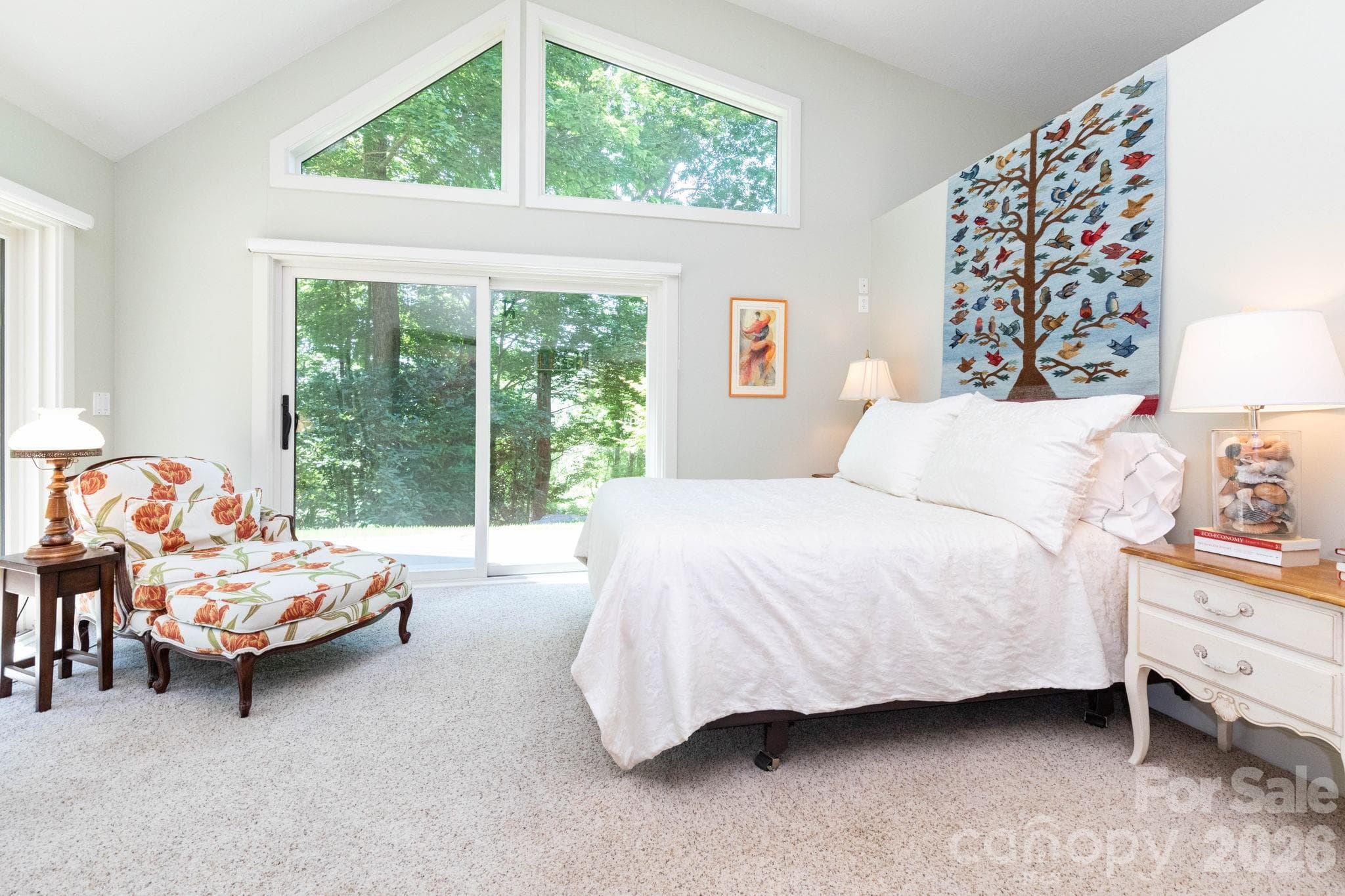 Bright and airy primary bedroom with vaulted ceilings, oversized windows, and sliding glass doors that seamlessly connect the interior to the surrounding natural beauty. - 29 Gardner Drive, Asheville