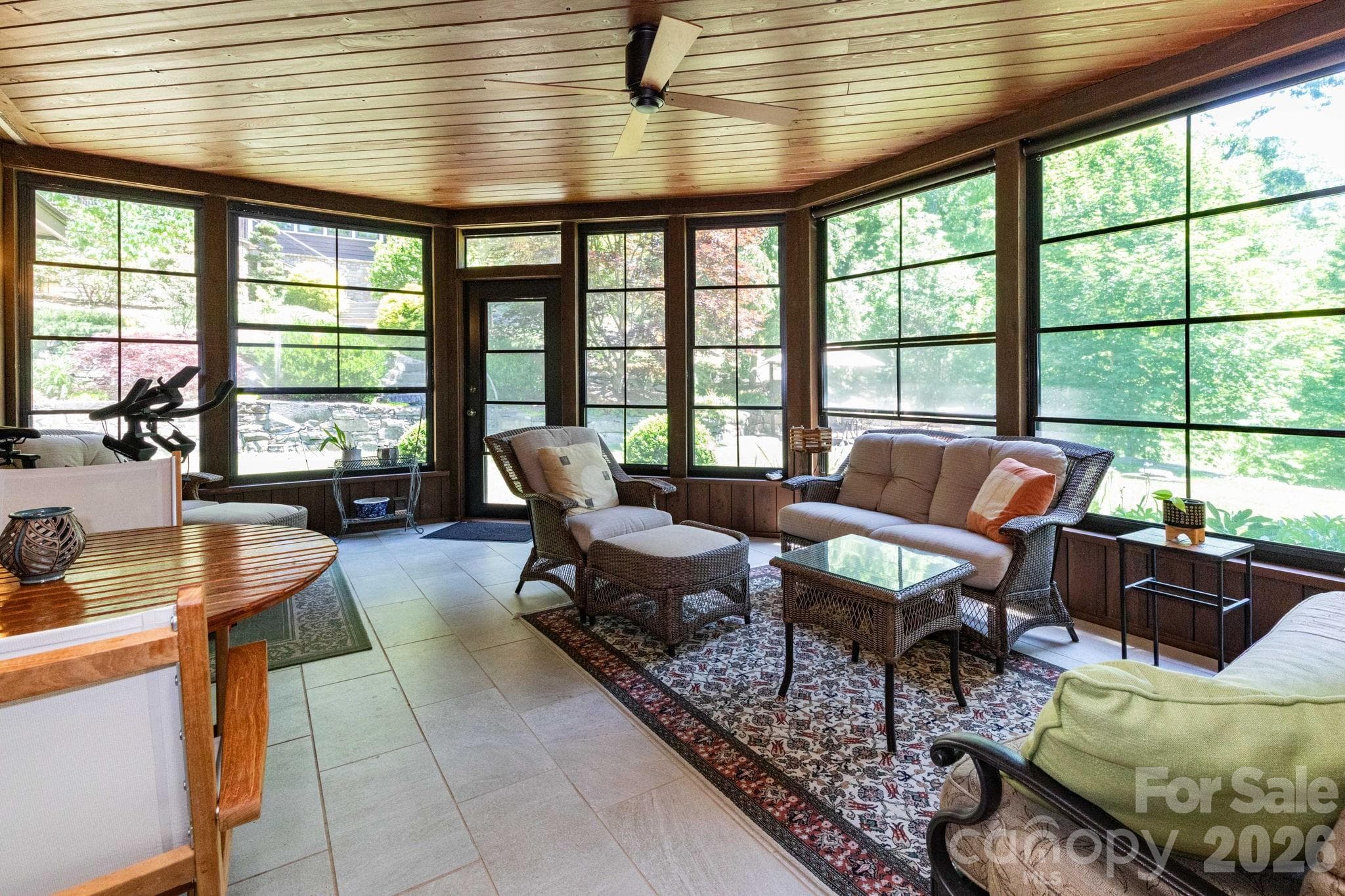 Stunning three-season screened patio with soaring wood ceilings, expansive windows, and peaceful views of the surrounding landscape—perfect for year-round enjoyment. - 29 Gardner Drive, Asheville