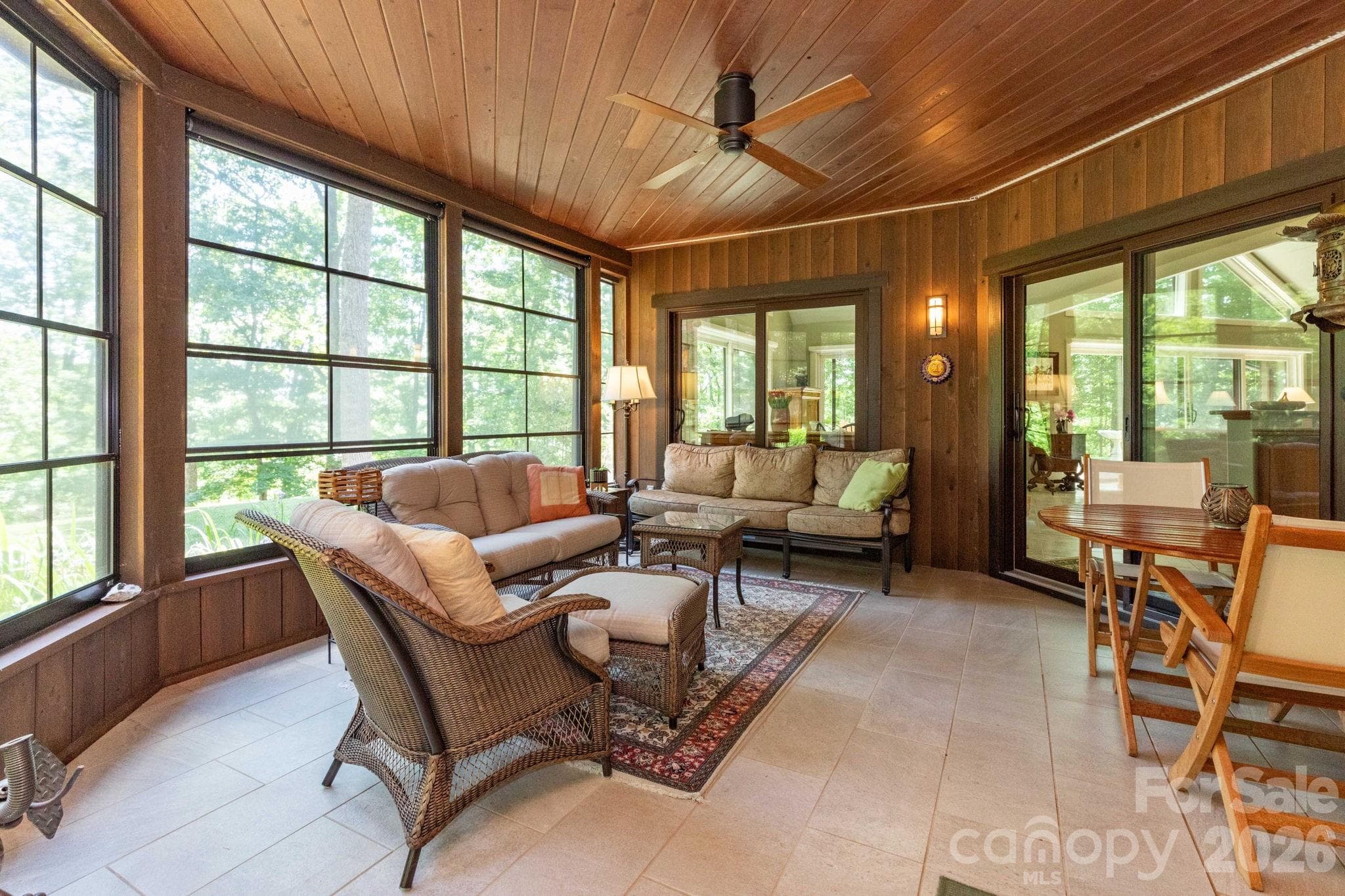 Stunning three-season screened patio with soaring wood ceilings, expansive windows, and peaceful views of the surrounding landscape—perfect for year-round enjoyment. - 29 Gardner Drive, Asheville