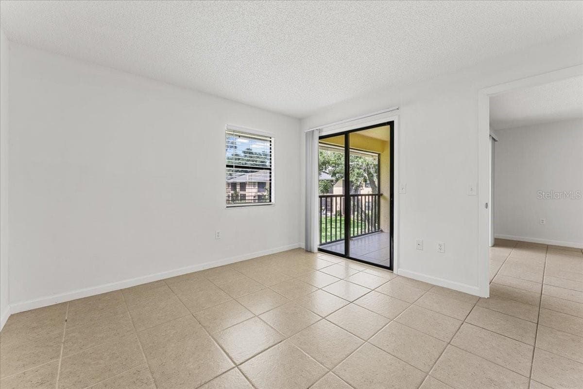 Primary bedroom with slider to screened porch balcony - 3001 58TH AVE S #1106, ST PETERSBURG