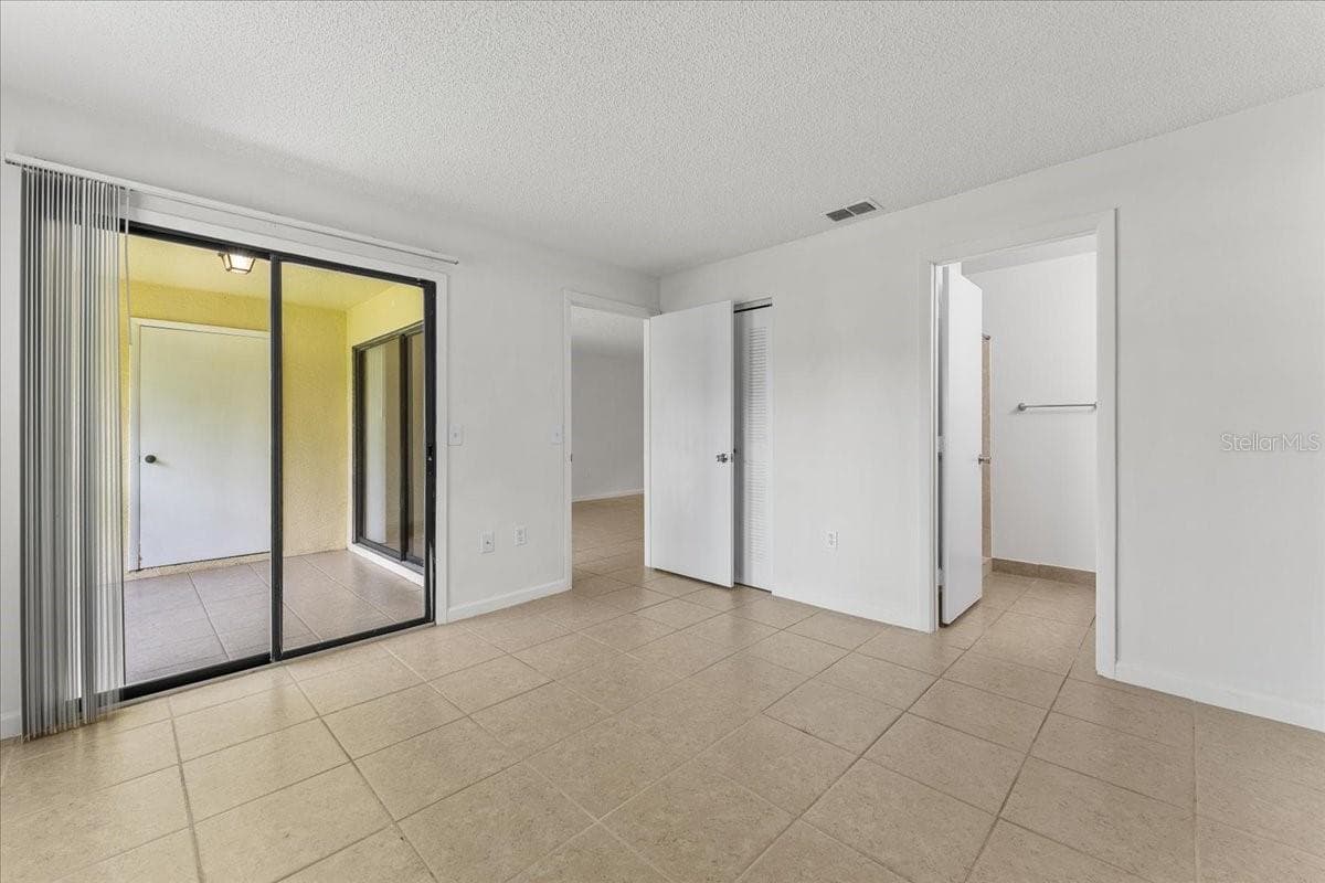Primary bedroom with slider to screened porch and ensuite bath - 3001 58TH AVE S #1106, ST PETERSBURG