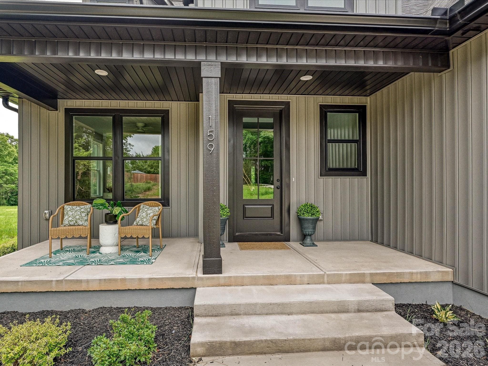 Charming covered front porch welcomes you with modern finishes, stylish seating, and the perfect space to relax and enjoy the peaceful surroundings. - Statesville
