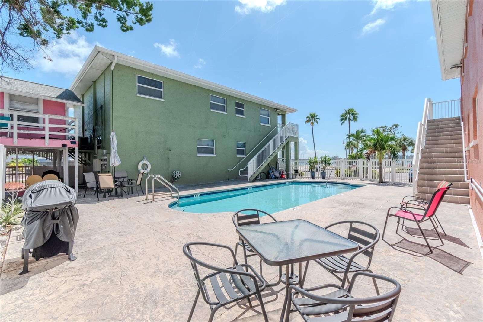 GREAT DECK AREA AROUND POOL, COMPLETE WITH GAS GRILL, TABLES AND CHAIRS - 5605 SHORE BLVD S #1B, GULFPORT