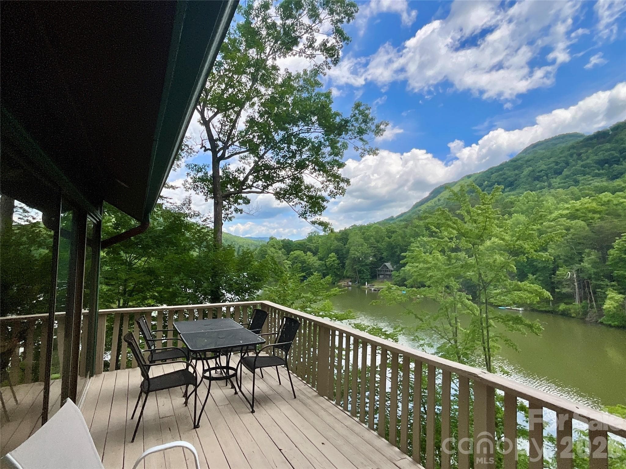 Peaceful lakeside setting with beautiful water and mountain views, complemented by a spacious wraparound deck—perfect for relaxing, grilling, and enjoying the scenery. - Lake Lure