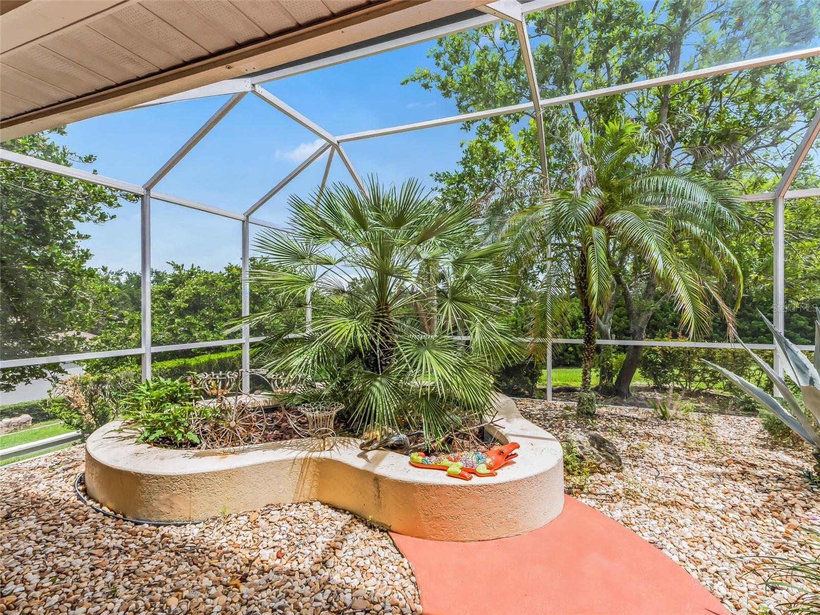Lanai has interesting planting areas - 5321 GREENS DR, LADY LAKE