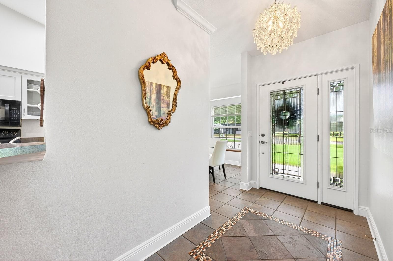 Step through the elegant ETCHED-GLASS FRONT DOOR with matching sidelight and immediately notice the STUNNING CHANDELIER (2021). - 2706 HARGILL DR, ORLANDO
