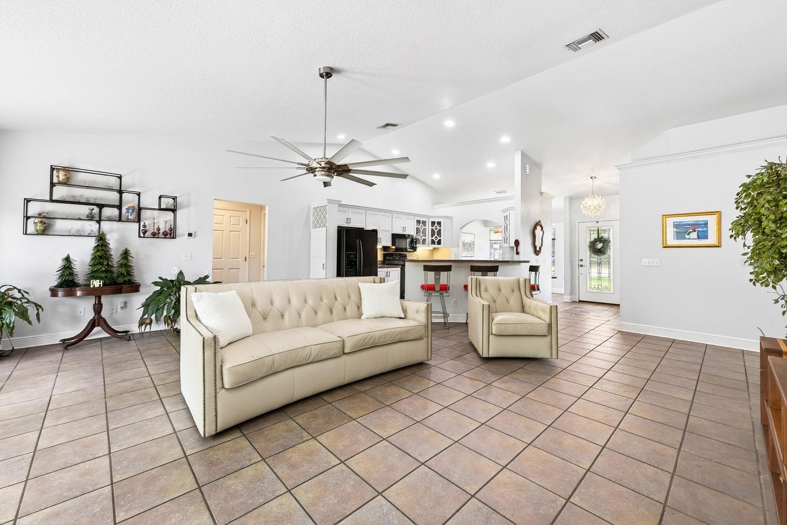A spacious Family Room impresses with soaring vaulted ceilings, a STYLISH SLINGER CEILING FAN (2021), and a beautiful MASONRY WOOD-BURNING FIREPLACE. - 2706 HARGILL DR, ORLANDO