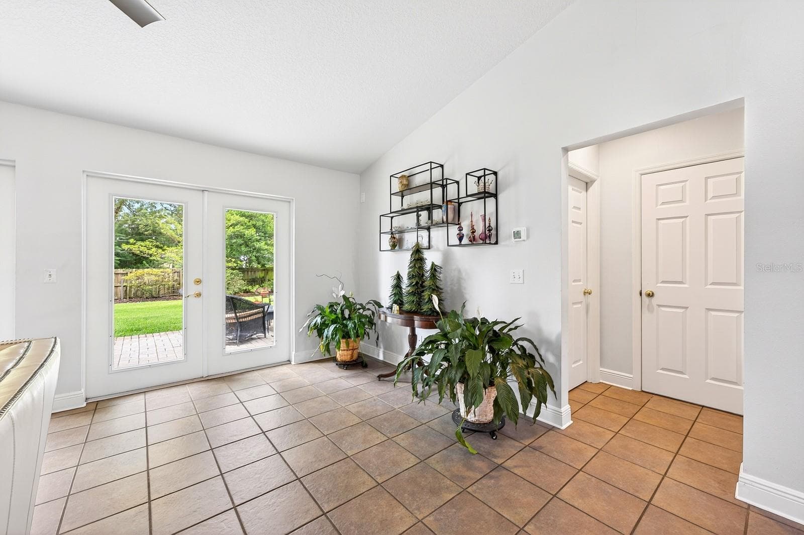 Two sets of GLASS FRENCH DOORS fill the space with NATURAL LIGHT and open to the backyard patio area. - 2706 HARGILL DR, ORLANDO
