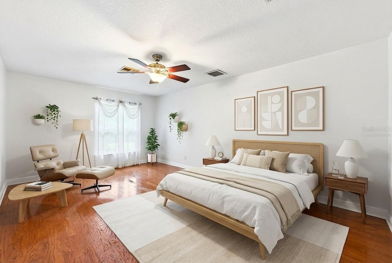 The generous Primary Suite serves as a relaxing retreat, featuring HARDWOOD FLOORING, a sleek ceiling fan, peaceful backyard views, a walk-in closet, and an EN SUITE BATH. Virtually Staged - 2706 HARGILL DR, ORLANDO
