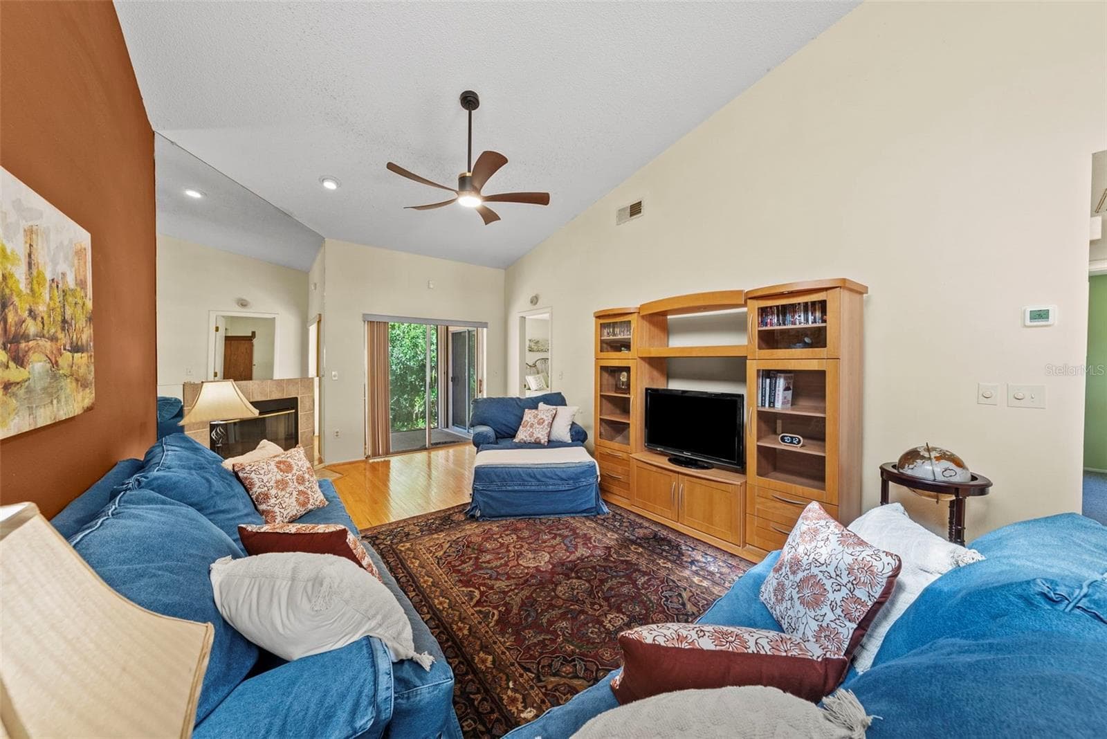 comfortable living room with fireplace and direct patio access. - 8601 TWIN FARMS PL, TAMPA