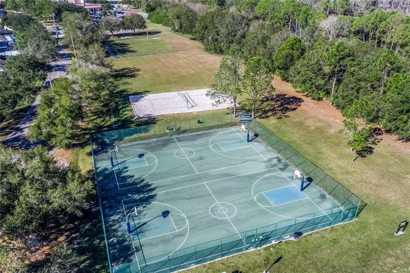 Aerial view of community basketball courts and open green space. - 8601 TWIN FARMS PL, TAMPA