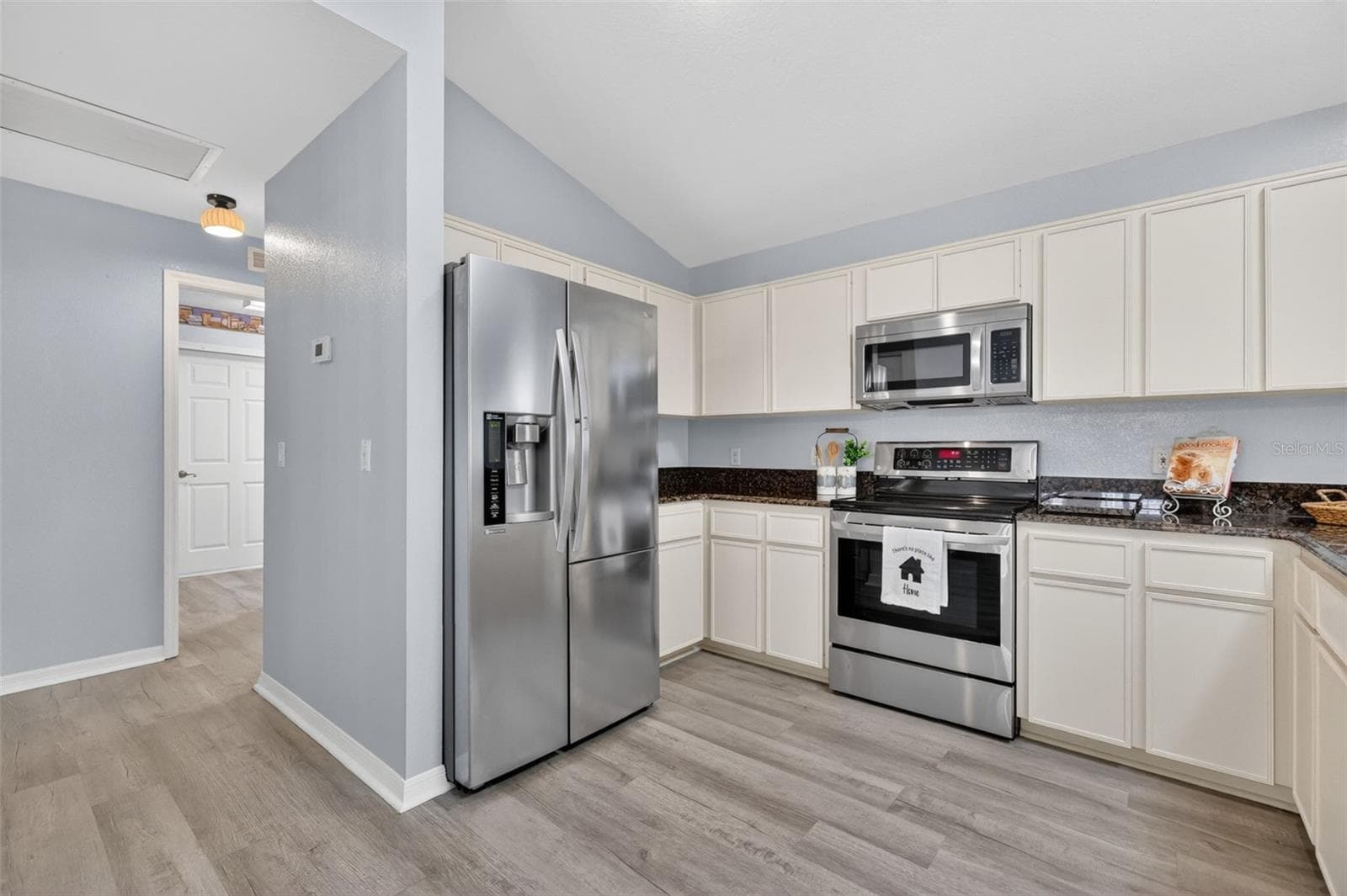 Efficient kitchen featuring granite countertops, stainless steel stove and refrigerator, plus plenty of cupboard and counter space for storage and meal preparation. - 17808 SE 115TH CT, SUMMERFIELD