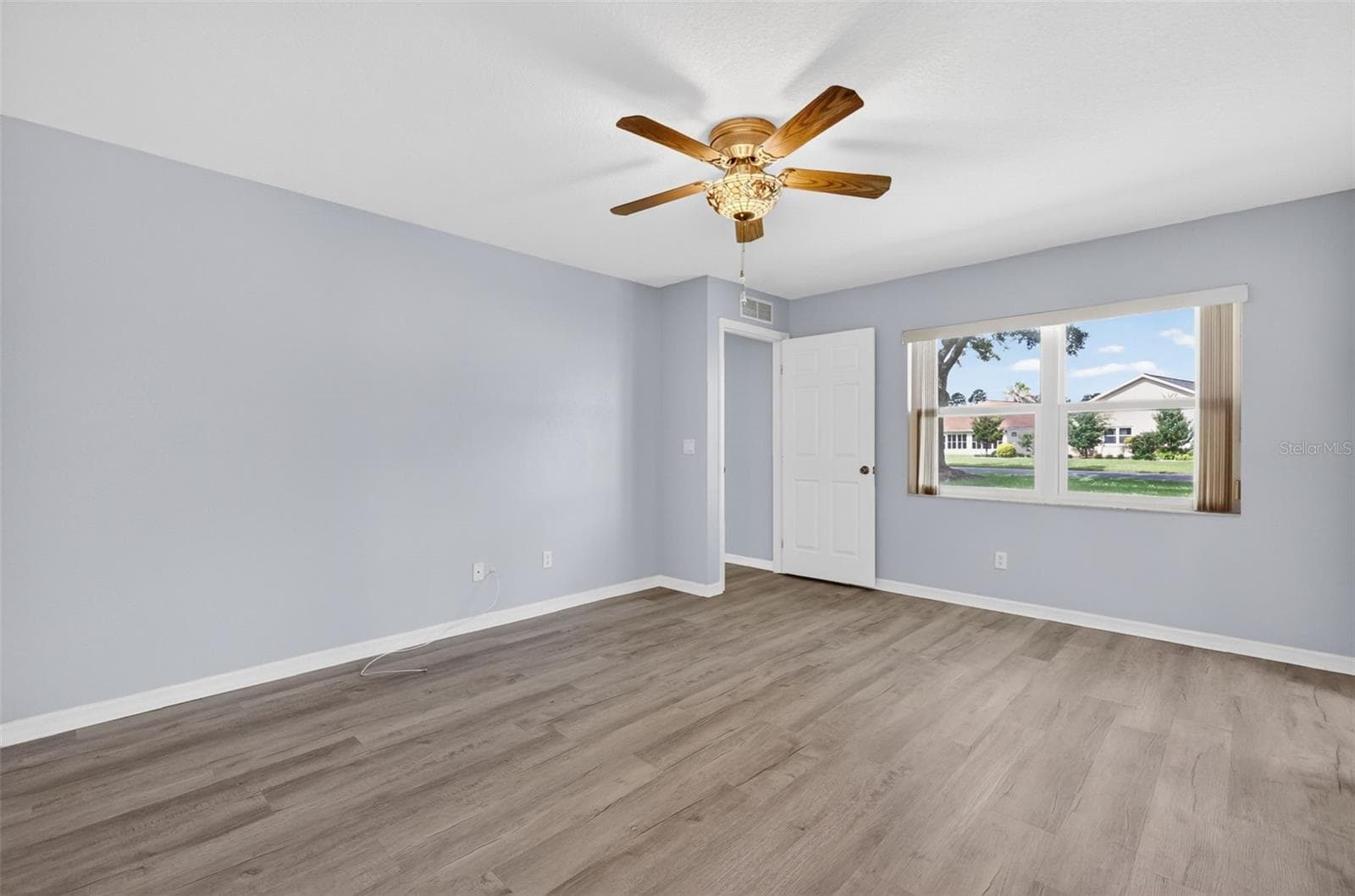 Primary Bedroom 1 features a stained glass ceiling fan/light, walk-in closet, and en suite bathroom. - 17808 SE 115TH CT, SUMMERFIELD