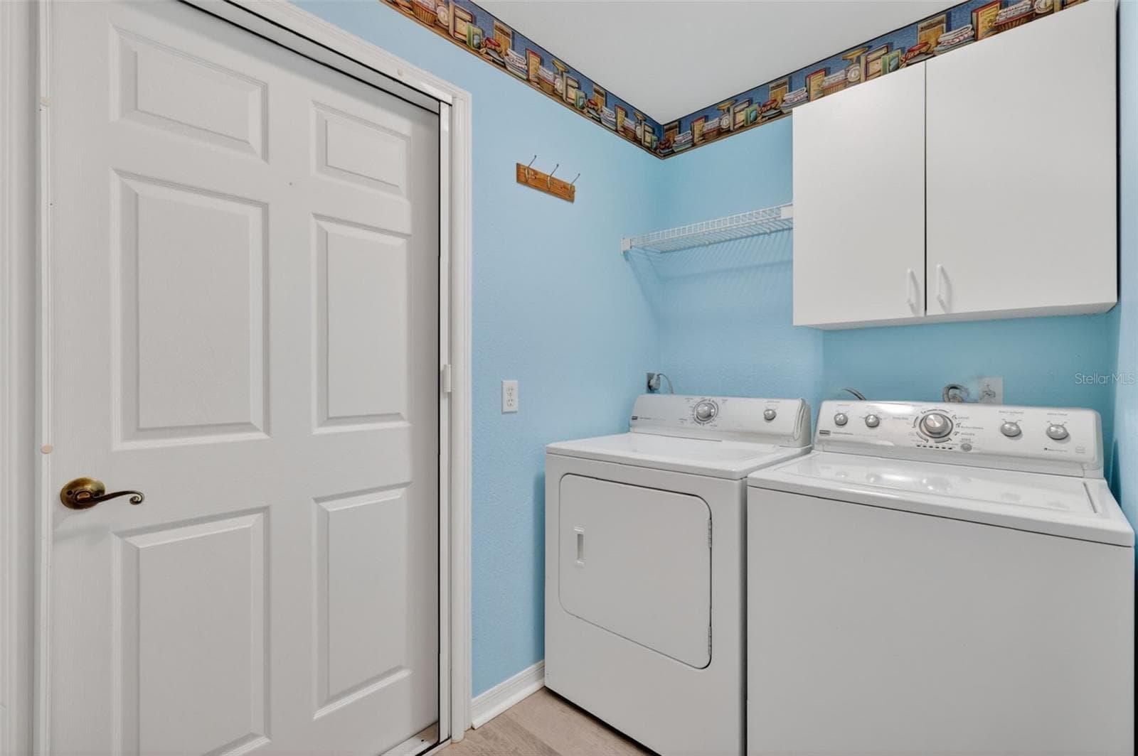 Inside laundry room with storage cabinets and closet. - 17808 SE 115TH CT, SUMMERFIELD