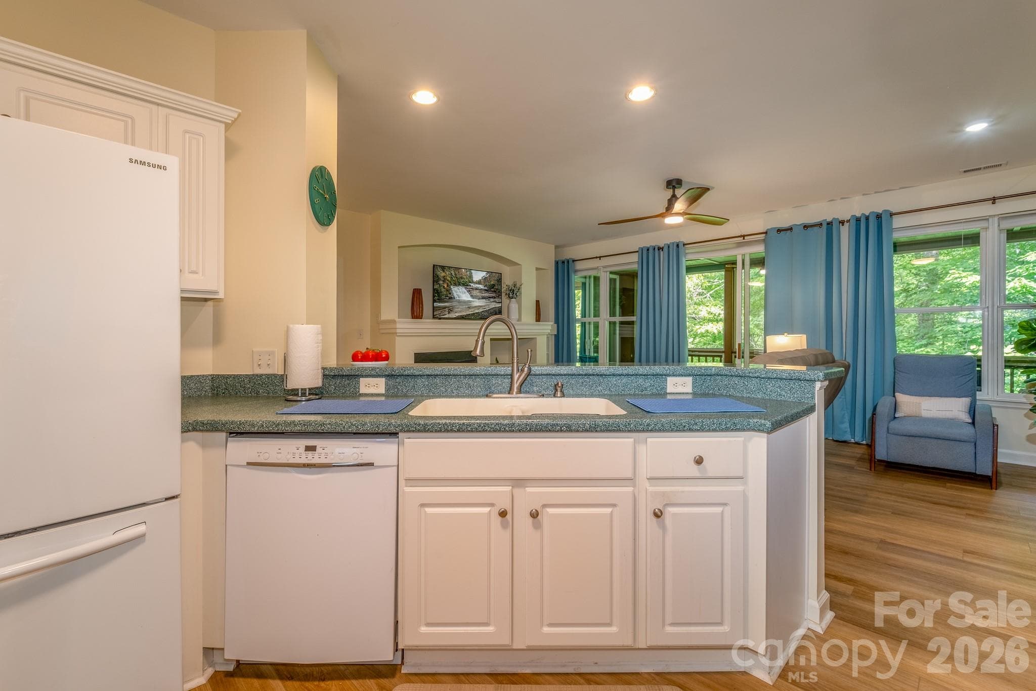Kitchen with Breakfast Bar – Spacious kitchen featuring bar seating, generous prep space, and an open view into the living room and fireplace. - 99 Ridgetop Circle, Brevard