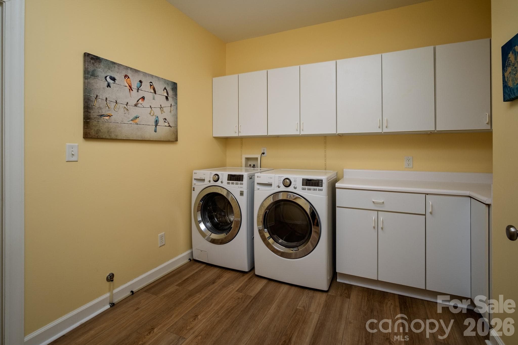 Oversized Laundry / Utility Room – Spacious laundry room featuring abundant cabinet storage, folding counter space, and full-size washer and dryer. - 99 Ridgetop Circle, Brevard