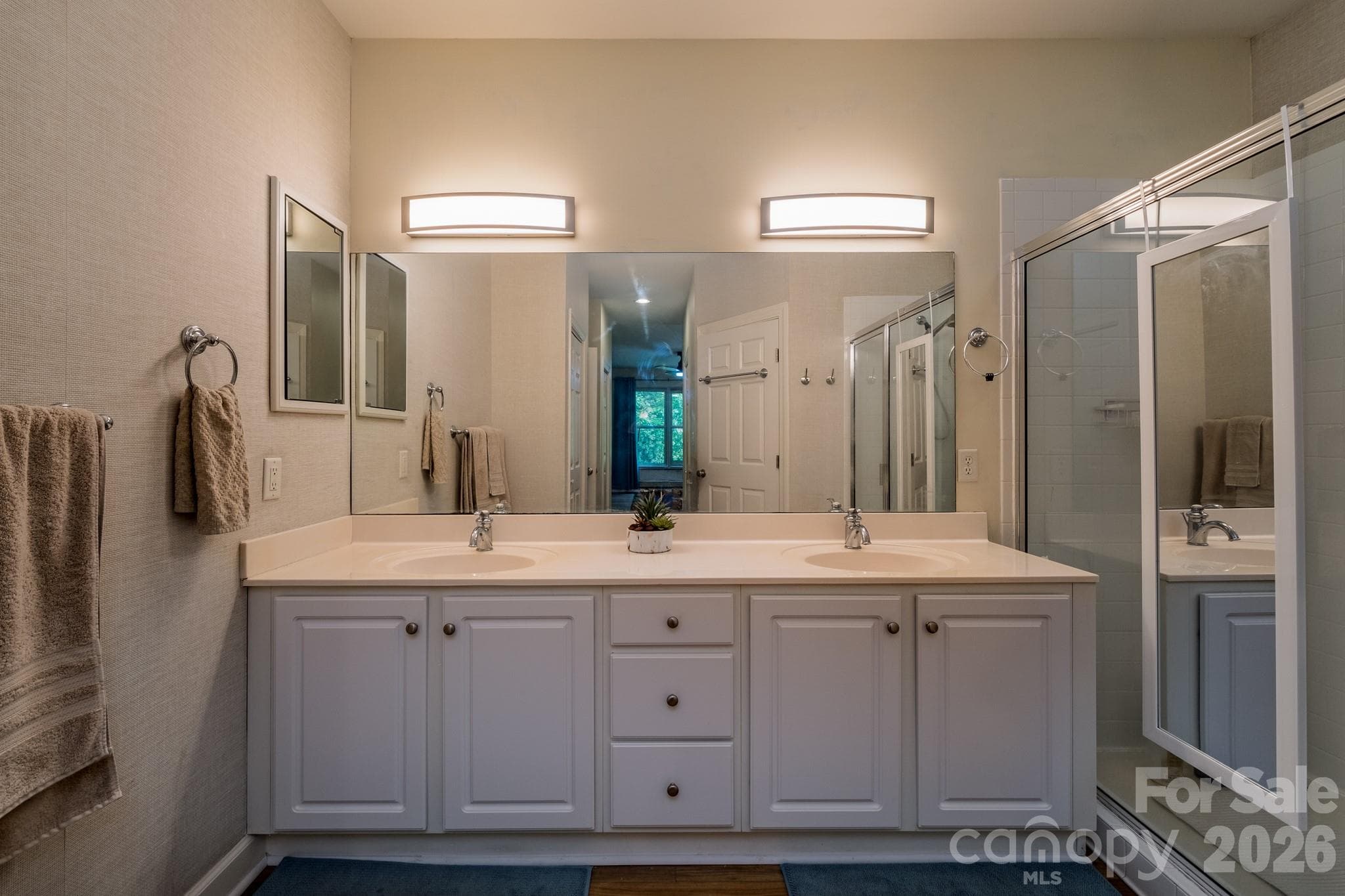Dual Vanity Primary Bath – Expansive en-suite bathroom with double vanity, generous counter space, and bright lighting for added convenience. - 99 Ridgetop Circle, Brevard