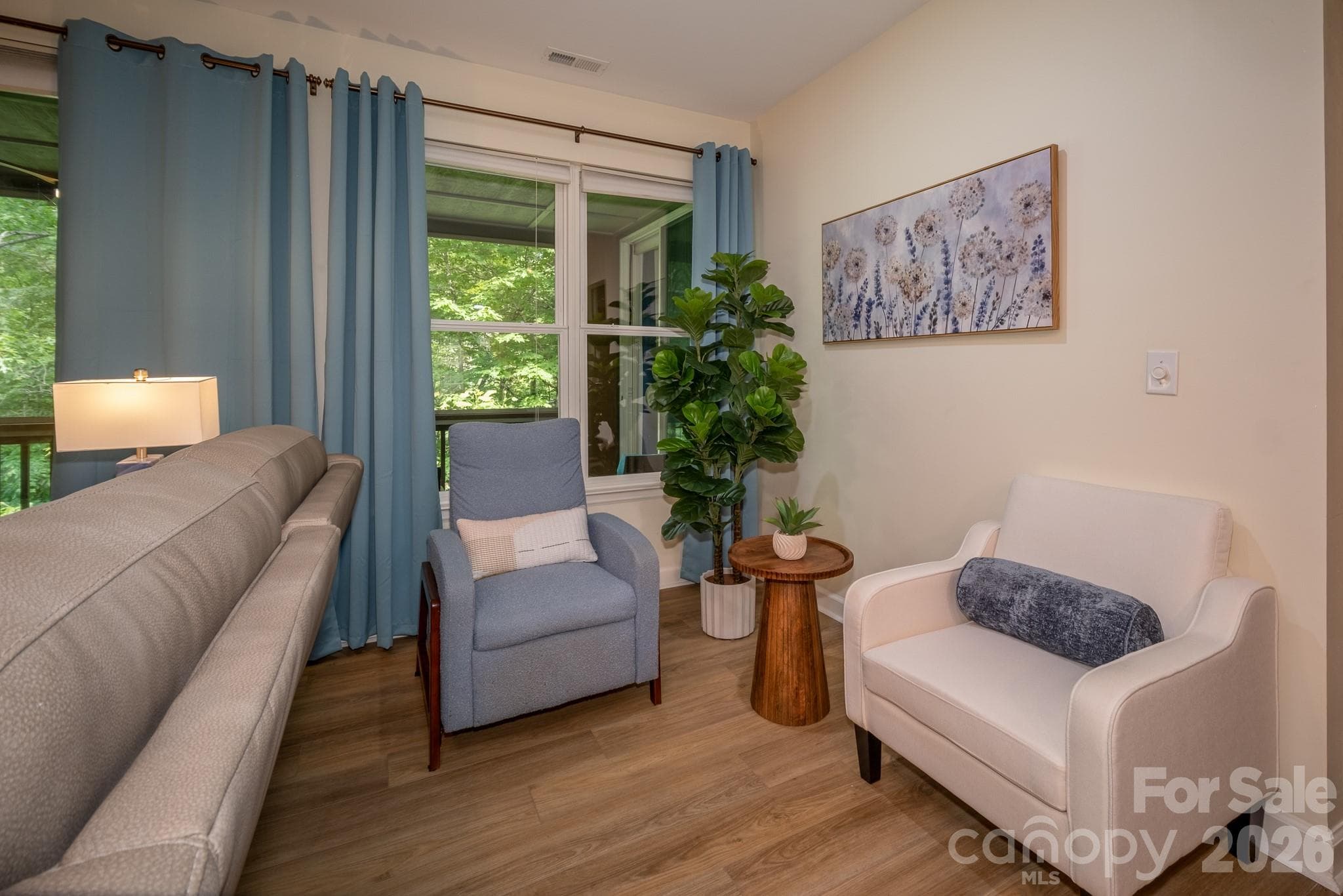 Flexible Dining or Sitting Area with Porch Access – Versatile space ideal for a dining area, featuring large windows, abundant natural light, and seamless access to the screened porch with peaceful wooded views beyond. - 99 Ridgetop Circle, Brevard