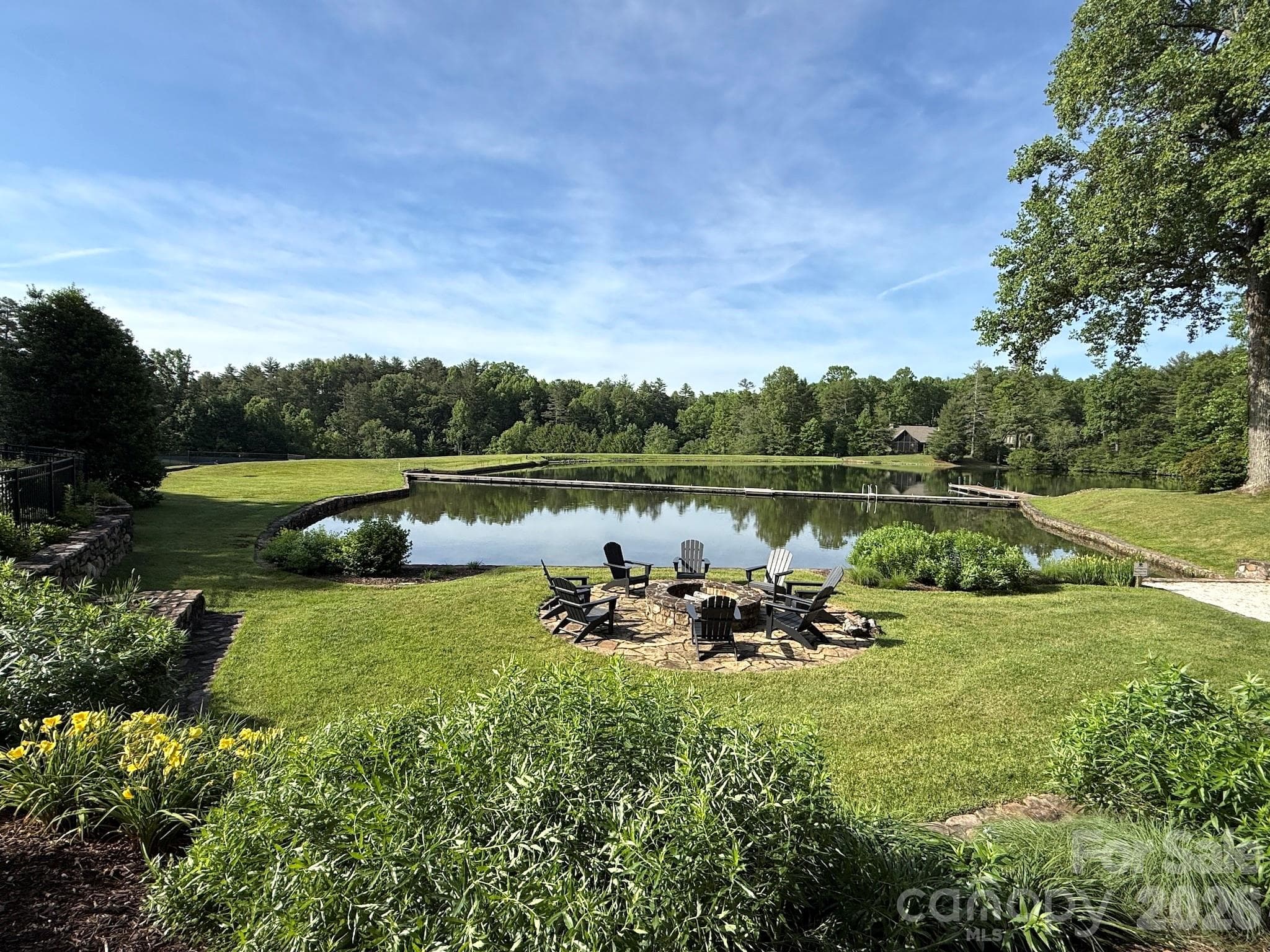 Lakeside Fire Pit Gathering Area – Enjoy evenings by the community lakeside fire pit, surrounded by manicured grounds, peaceful water views, and inviting seating perfect for gathering with friends and neighbors. - 99 Ridgetop Circle, Brevard
