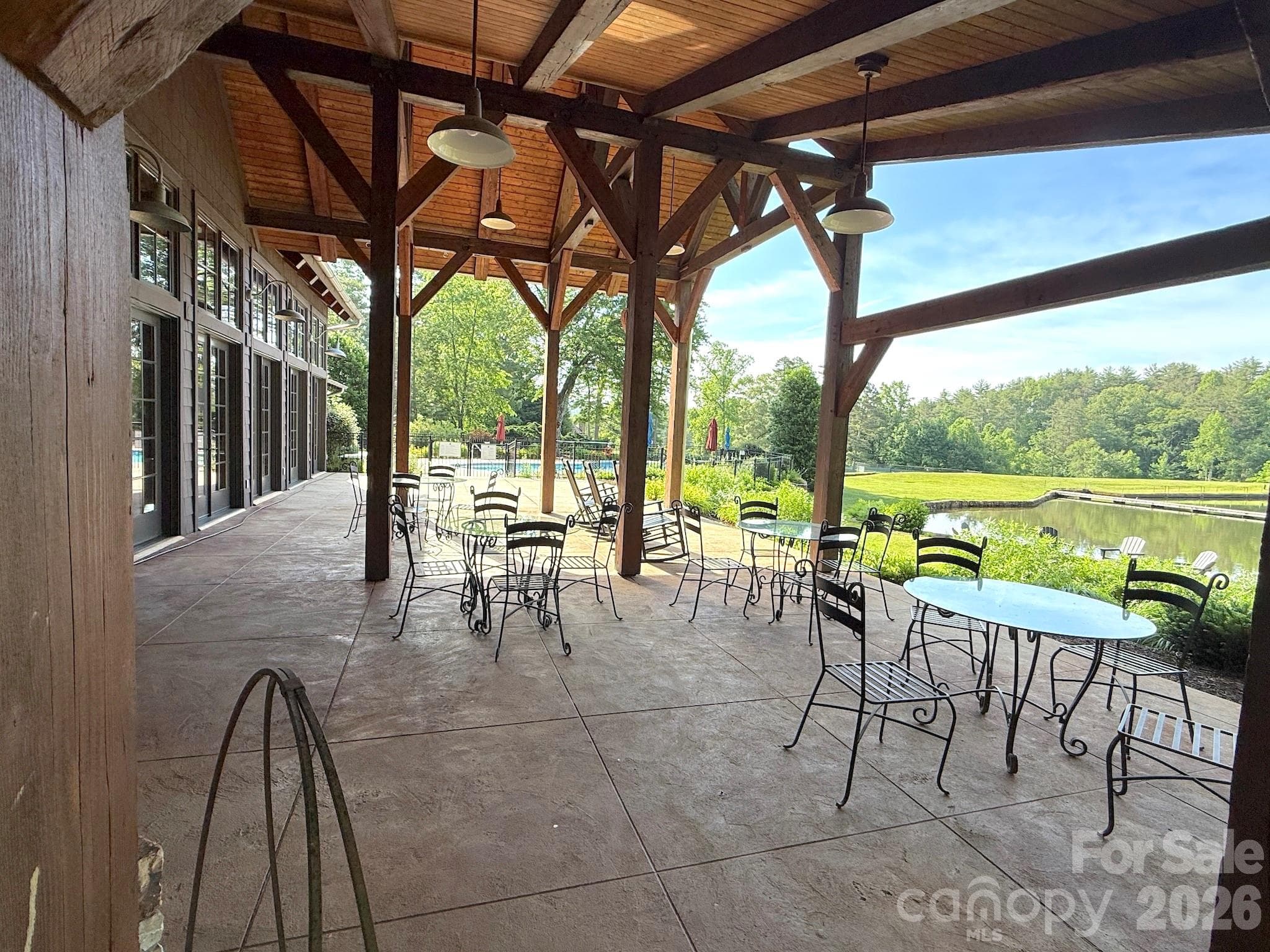 Covered Lakeside Pavilion – Stunning covered lakeside pavilion with exposed timber framing, gathering areas, and peaceful water views—perfect for outdoor dining, relaxing, or socializing with neighbors. - 99 Ridgetop Circle, Brevard