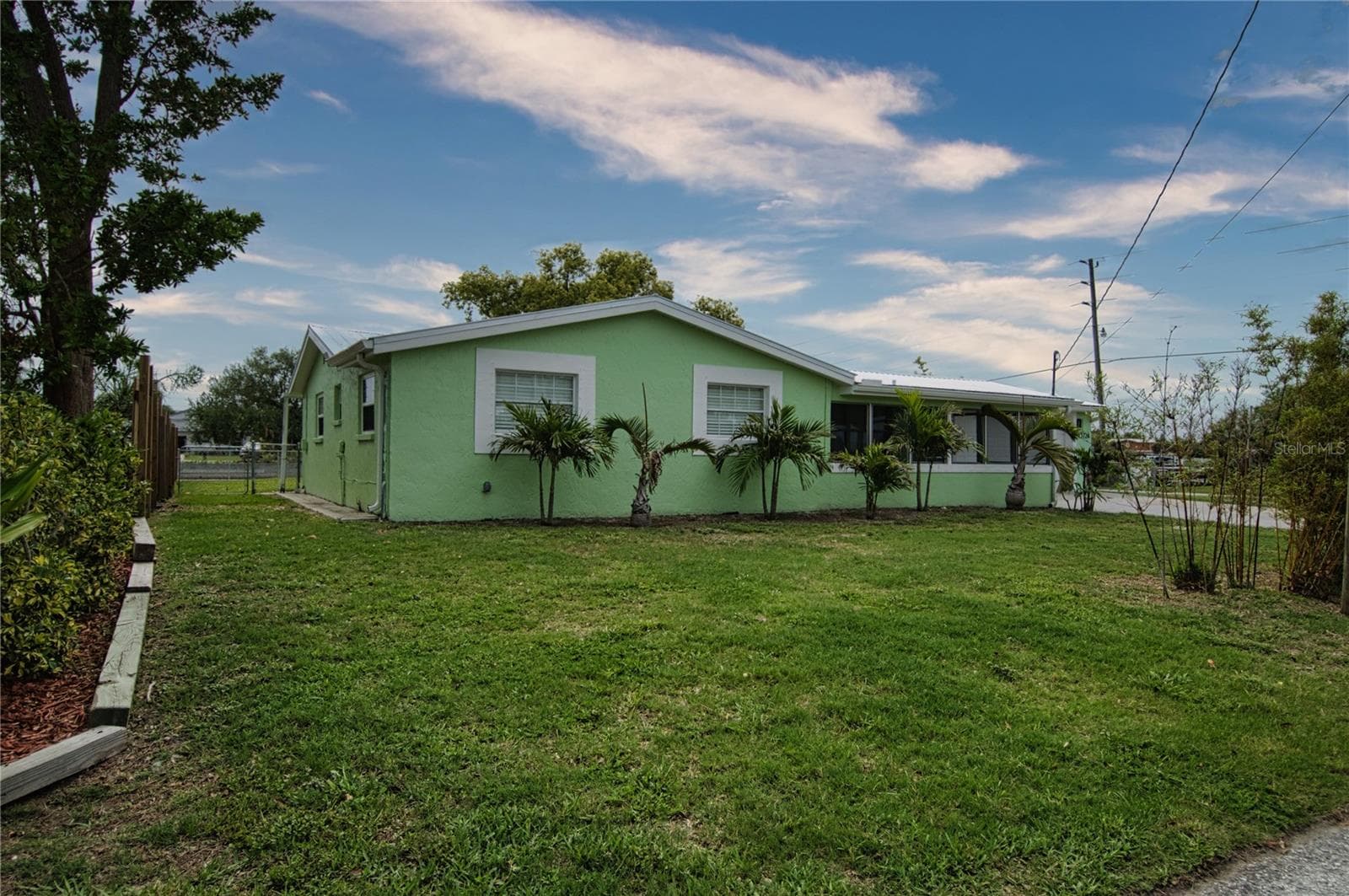 Expansive side yard as well graced by stately palm trees. - 13724 COX AVE, HUDSON