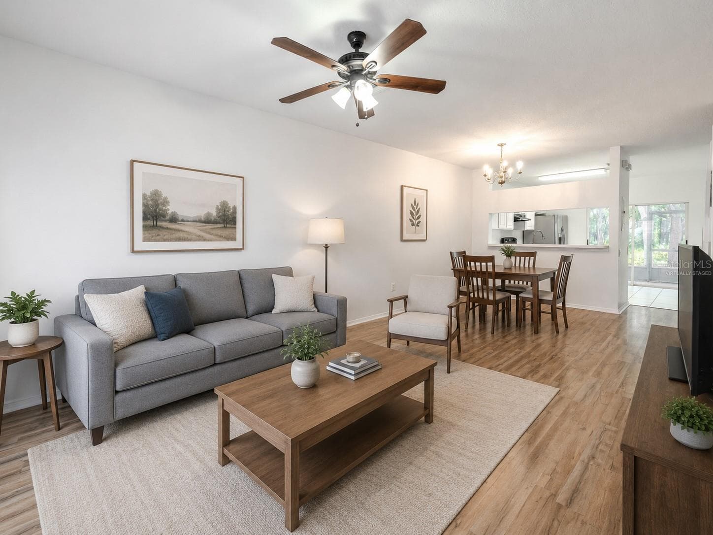 The Living room features neutral tones, wood laminate flooring, a ceiling fan with light kit and picture window. (Photo has been virtually staged.) - 2432 LAKE WOODBERRY CIR, BRANDON
